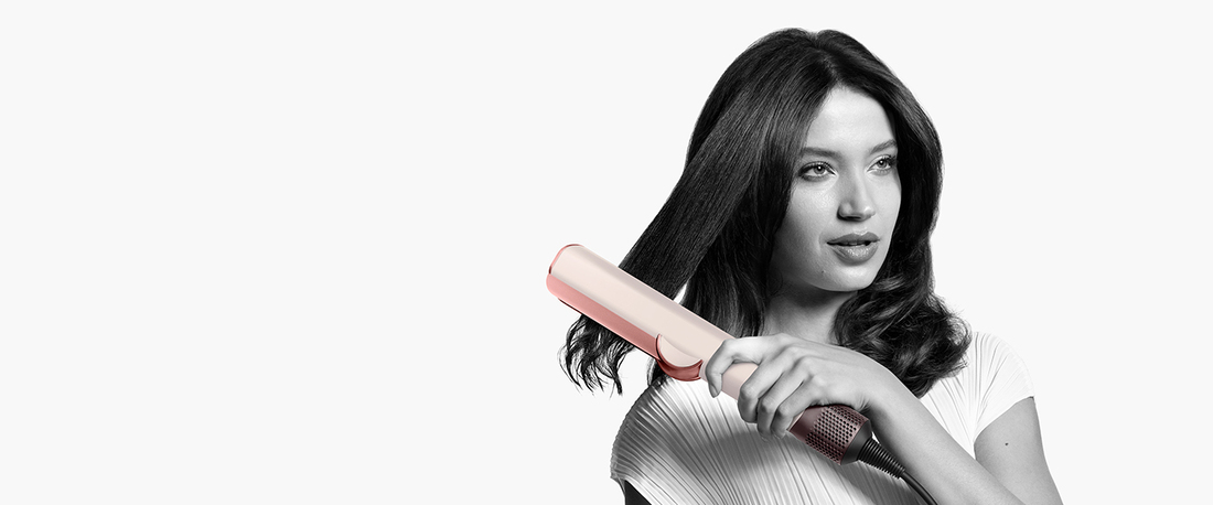 Mujer peinando cabello con plancha, monocromo.