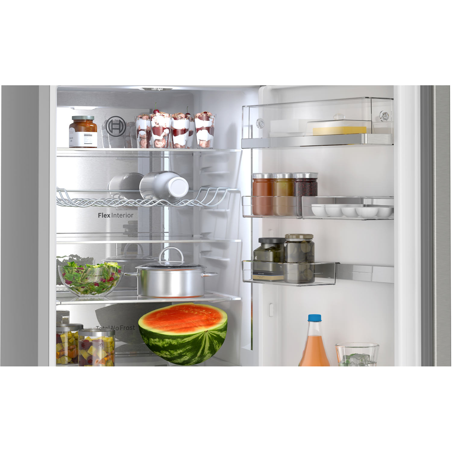 Refrigerator interior with shelves of food, including jars, a watermelon, and metal pots. Light inside.