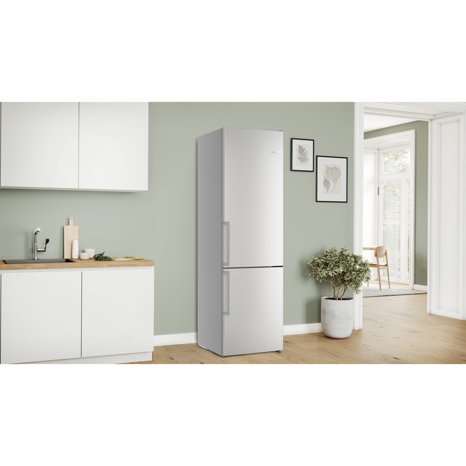 A silver refrigerator in a kitchen setting. A white cabinet and a cutting board are next to it.