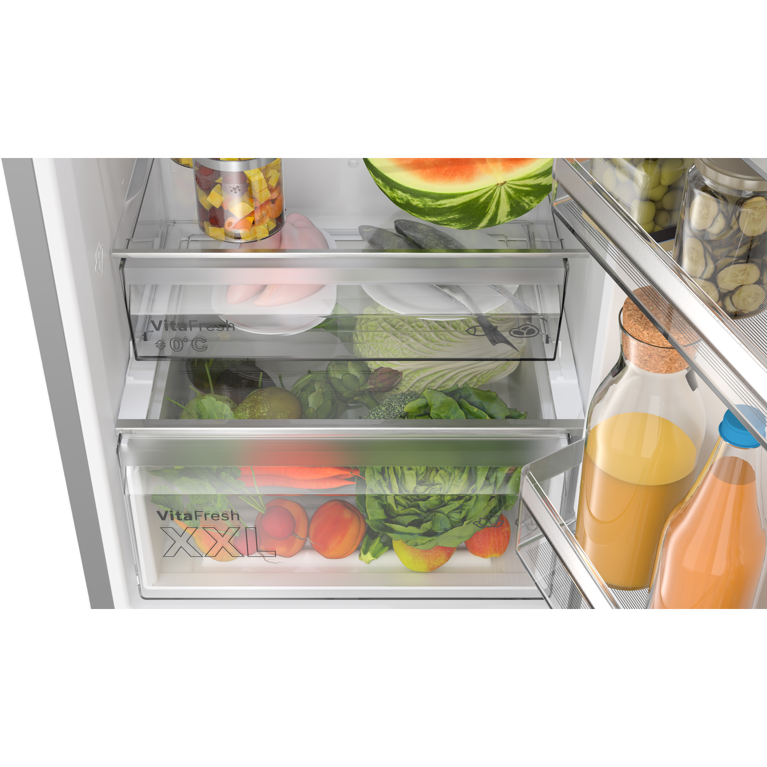 Refrigerator drawers filled with fruits and vegetables. Jars with pickles are visible.