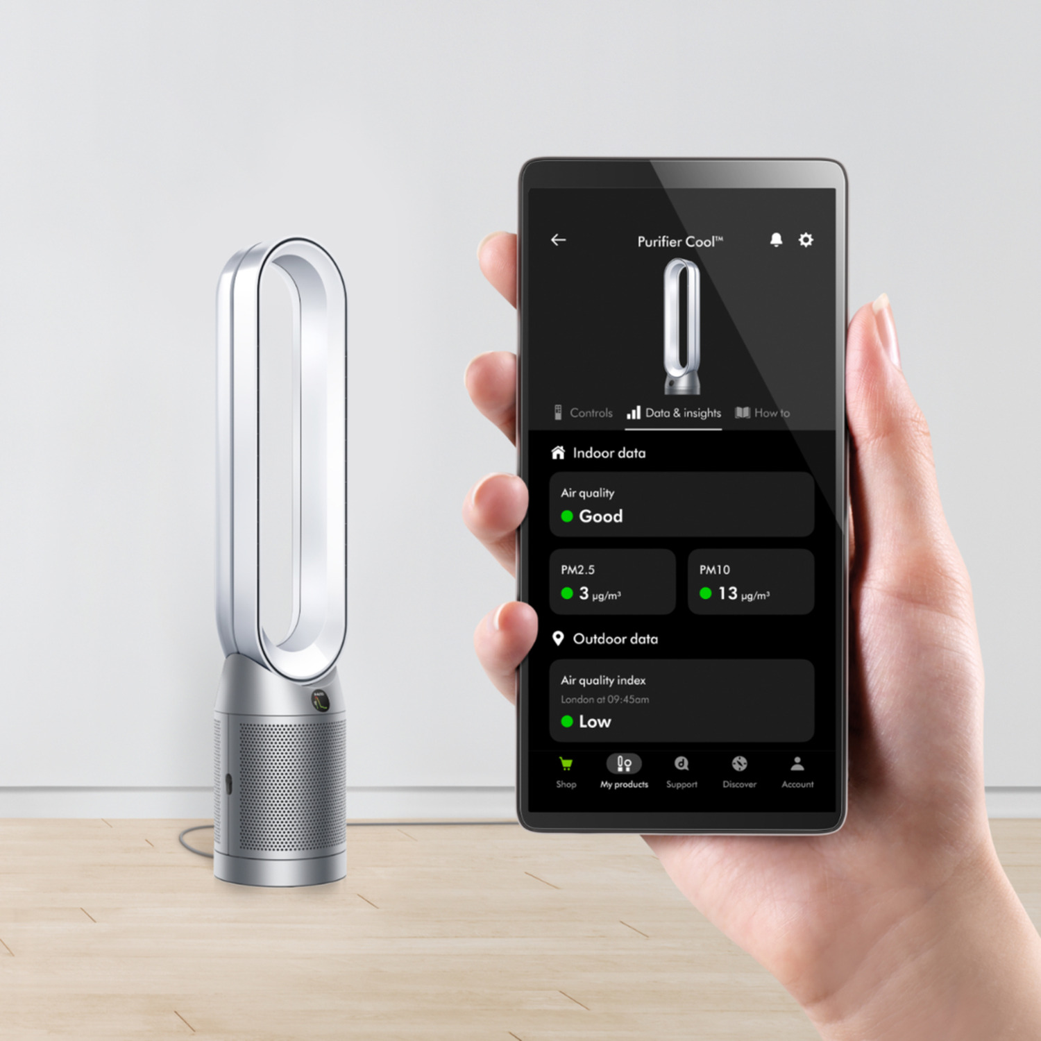 A person holding a smartphone displaying an air purifier interface.