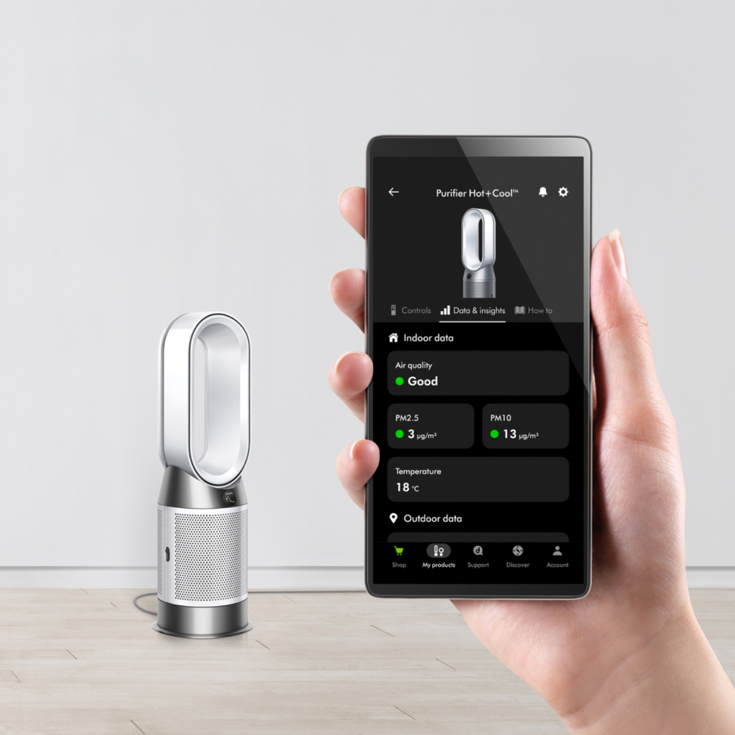 A person holding a smartphone that shows an air purifier's data and insights.