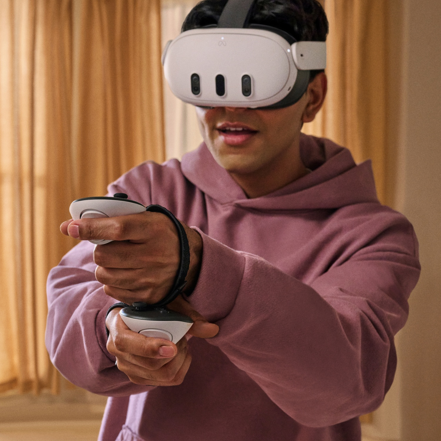 Un uomo con un visore VR, con i controller in mano, in una stanza.