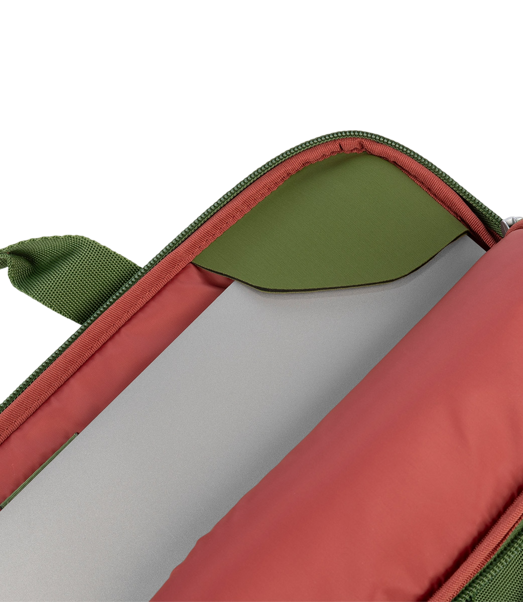 Eine offene Laptoptasche, grünes Äußeres, rotes Inneres, mit einem grauen Laptop, auf schwarzem Hintergrund.