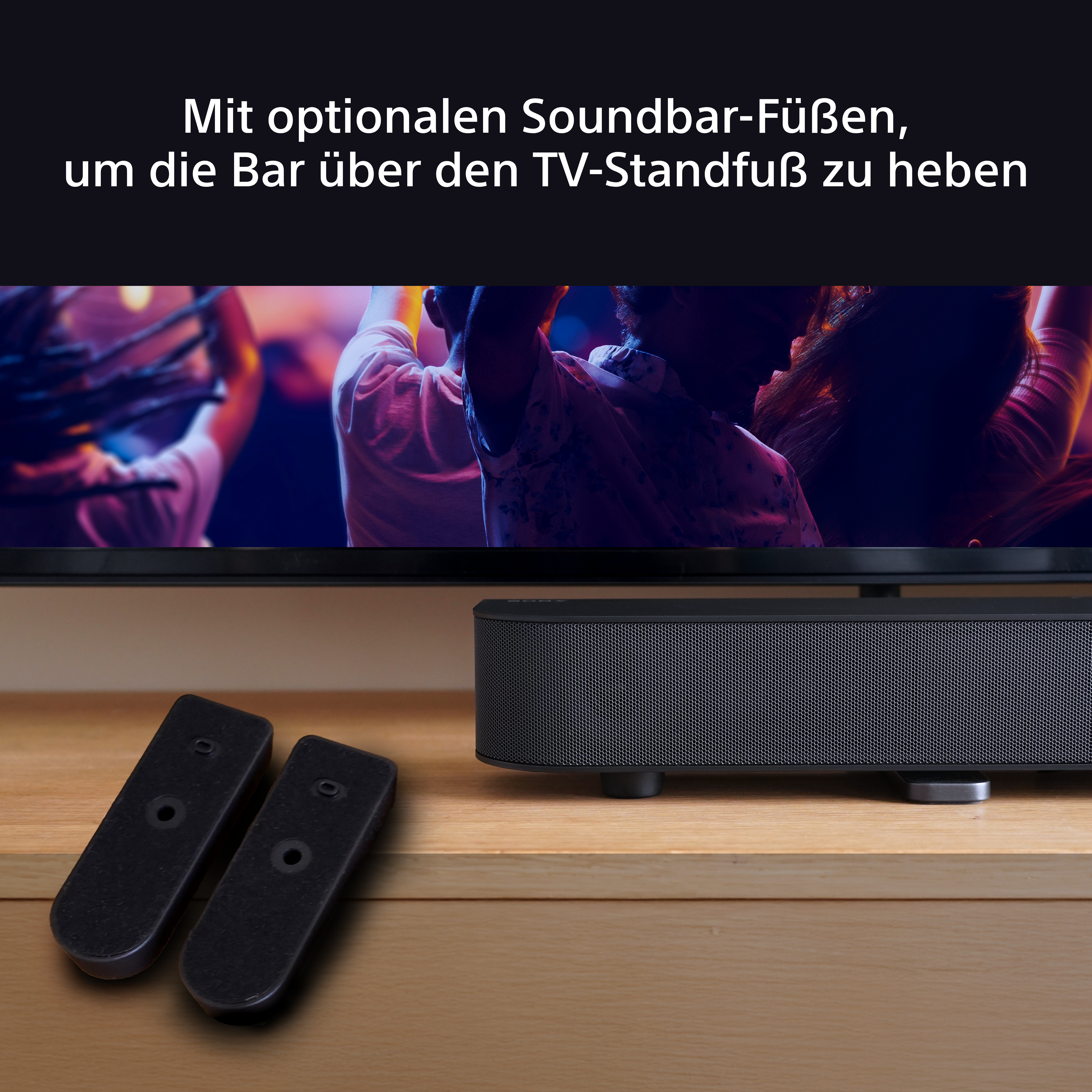 Eine Soundbar unter einem Fernseher, mit zwei Fernbedienungen.