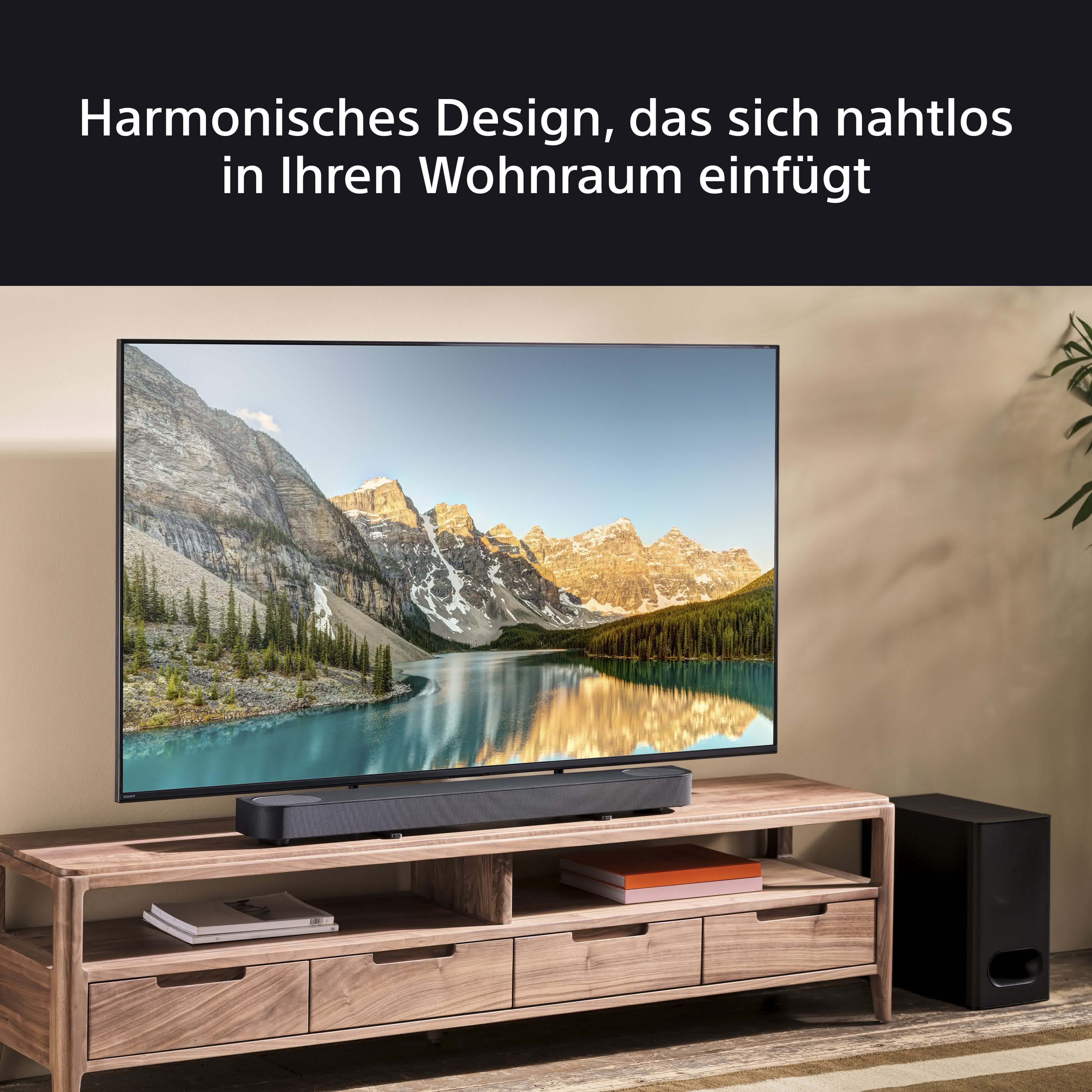 Fernseher auf Holzständer mit Soundbar. Berge und See im Hintergrund, Text über dem Fernseher.