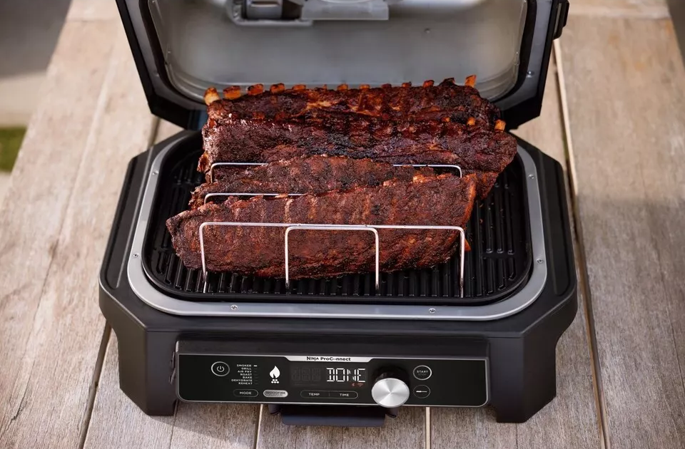 Ninja Pro grill sült bordával. A grill nyitva, digitális kijelzővel az elején.