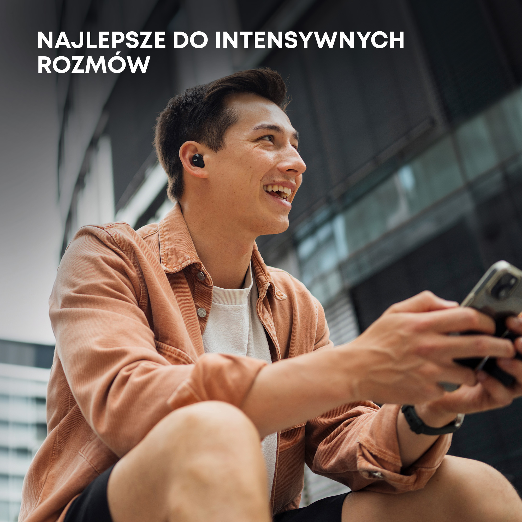 Mężczyzna uśmiechnięty, trzyma telefon, ma słuchawki. Tekst: Najlepsze do intensywnych rozmów.