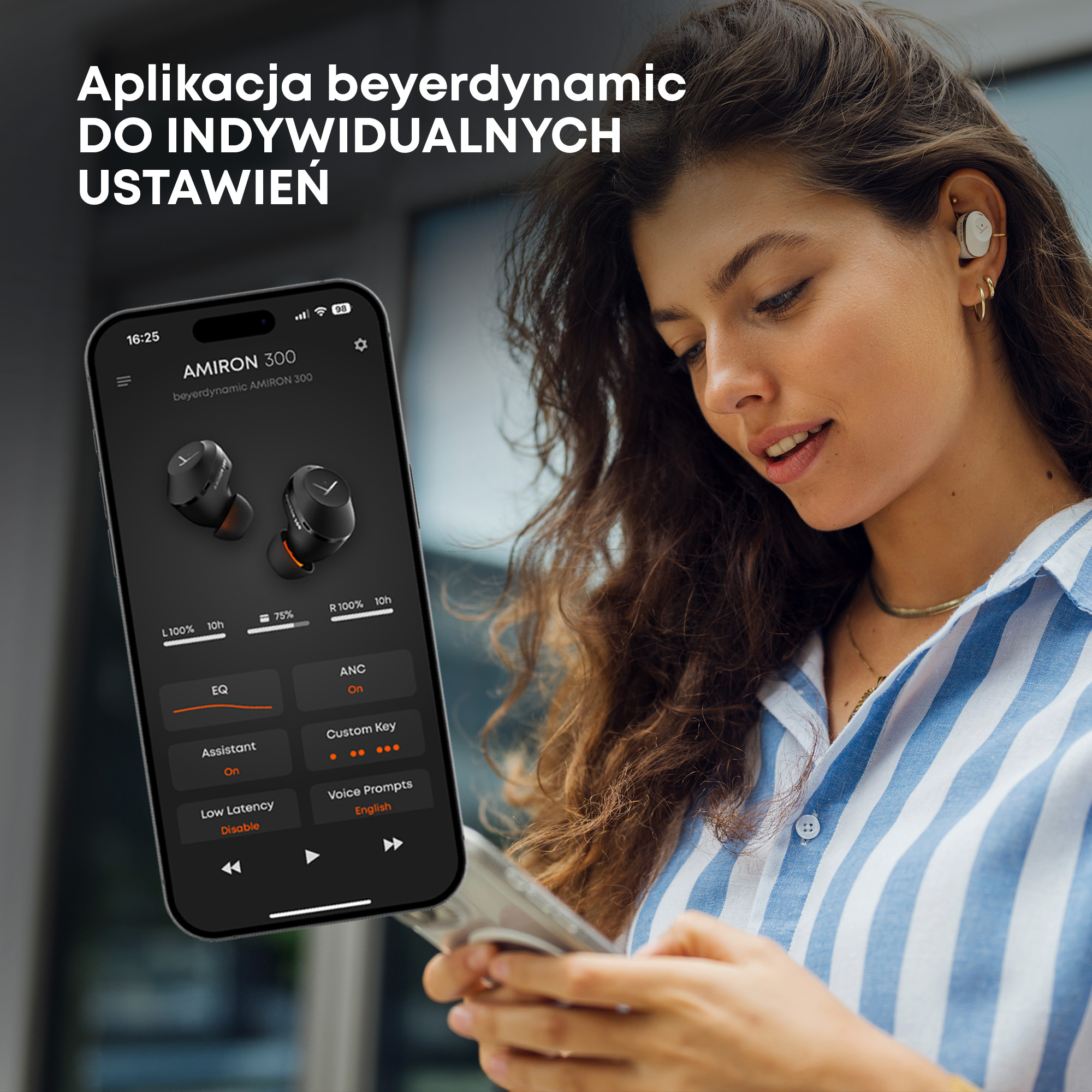 Kobieta trzyma telefon z aplikacją słuchawek. Ma słuchawki i koszulę w paski.