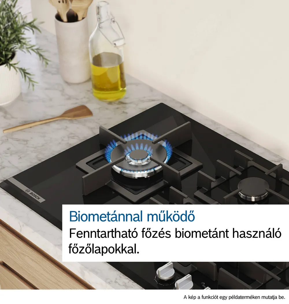 Közelkép egy modern gáztűzhelyről kék lángokkal. Fekete felület, fehér háttér.