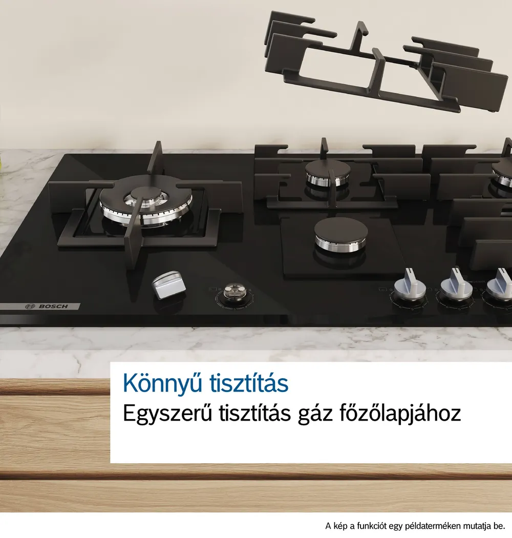 Fekete gáztűzhely öt égővel és egy leválasztott égőrácssal.