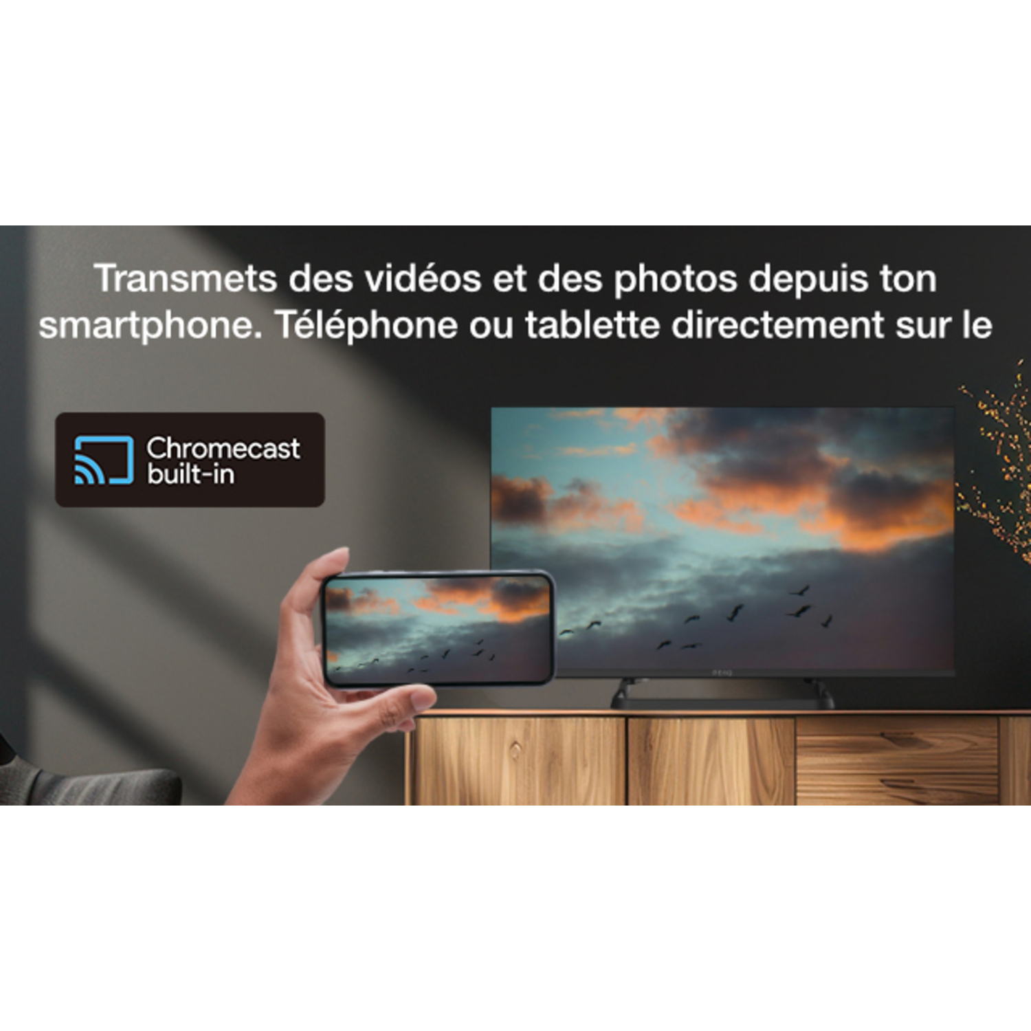 Une personne tient un smartphone montrant une télévision avec un arrière-plan.