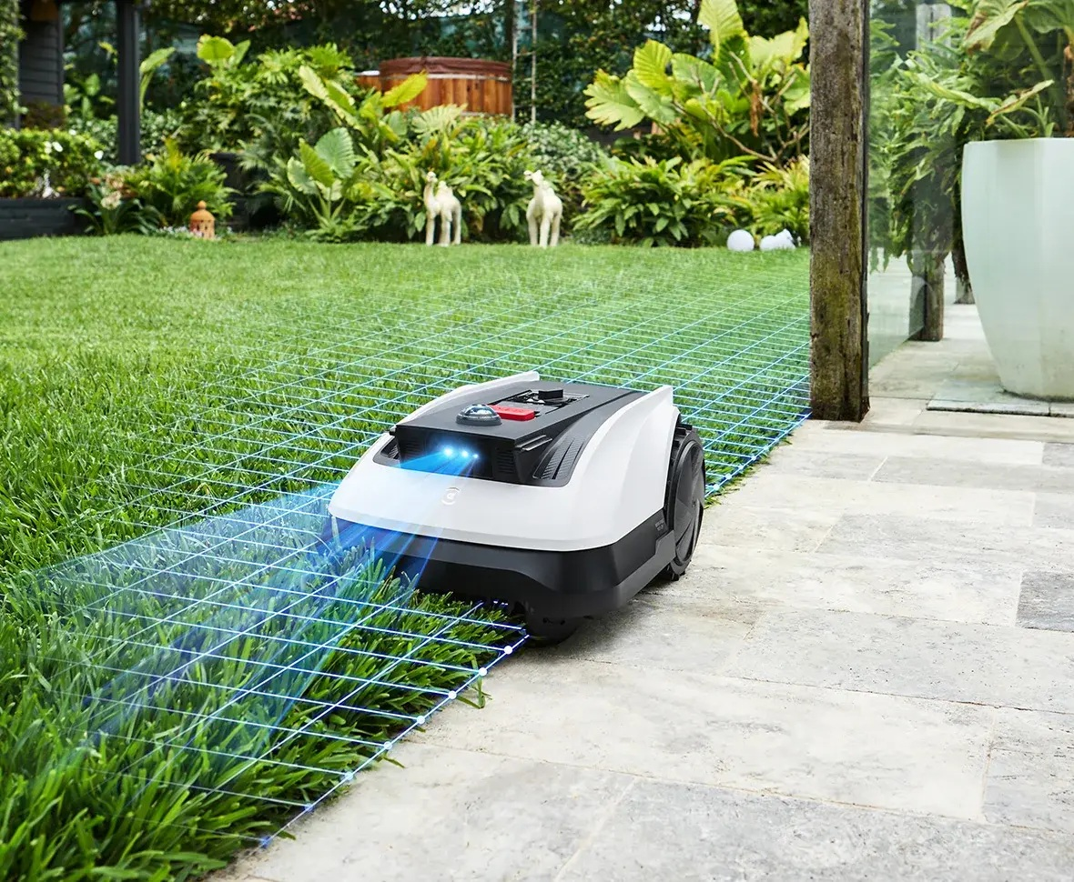Kosiarka robotyczna kosząca trawnik z niebieską nakładką siatki.
