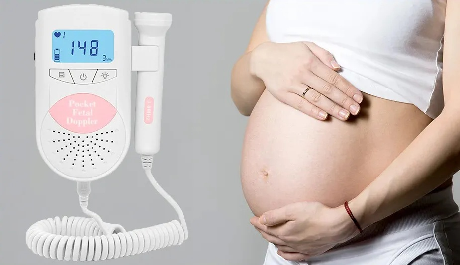 Kobieta w ciąży trzyma doppler płodowy i dotyka brzucha.