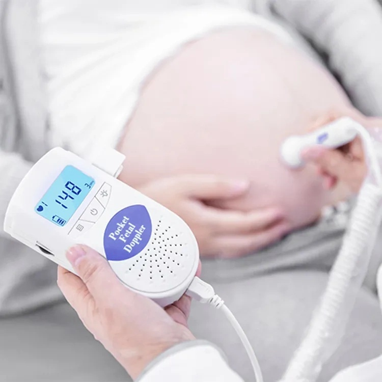 Brzuch kobiety w ciąży jest skanowany za pomocą dopplera płodowego. Urządzenie pokazuje tętno 148.