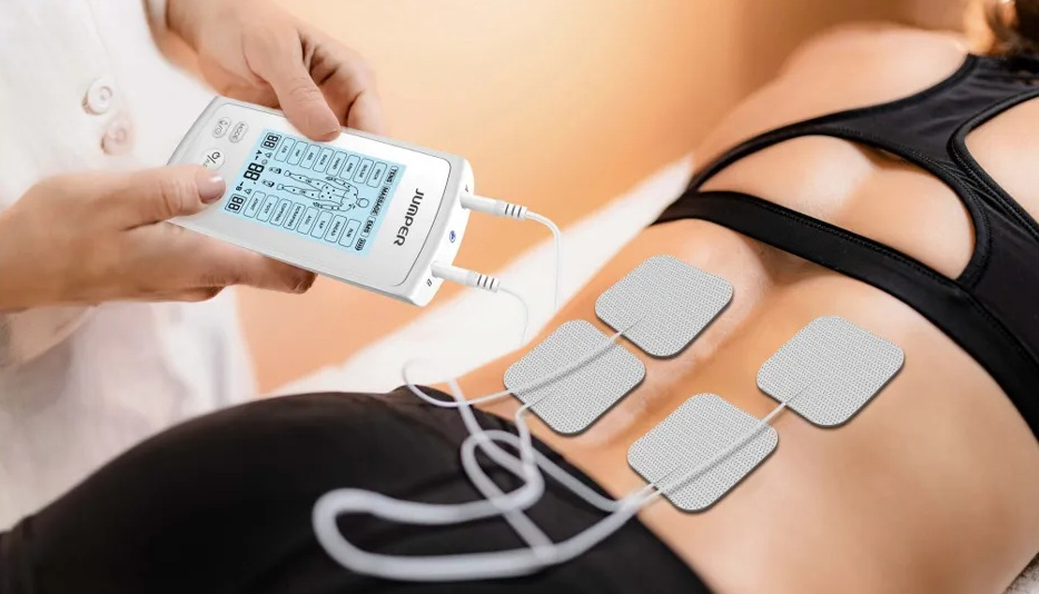 Kobieta otrzymuje elektroterapię na dolnej części pleców.