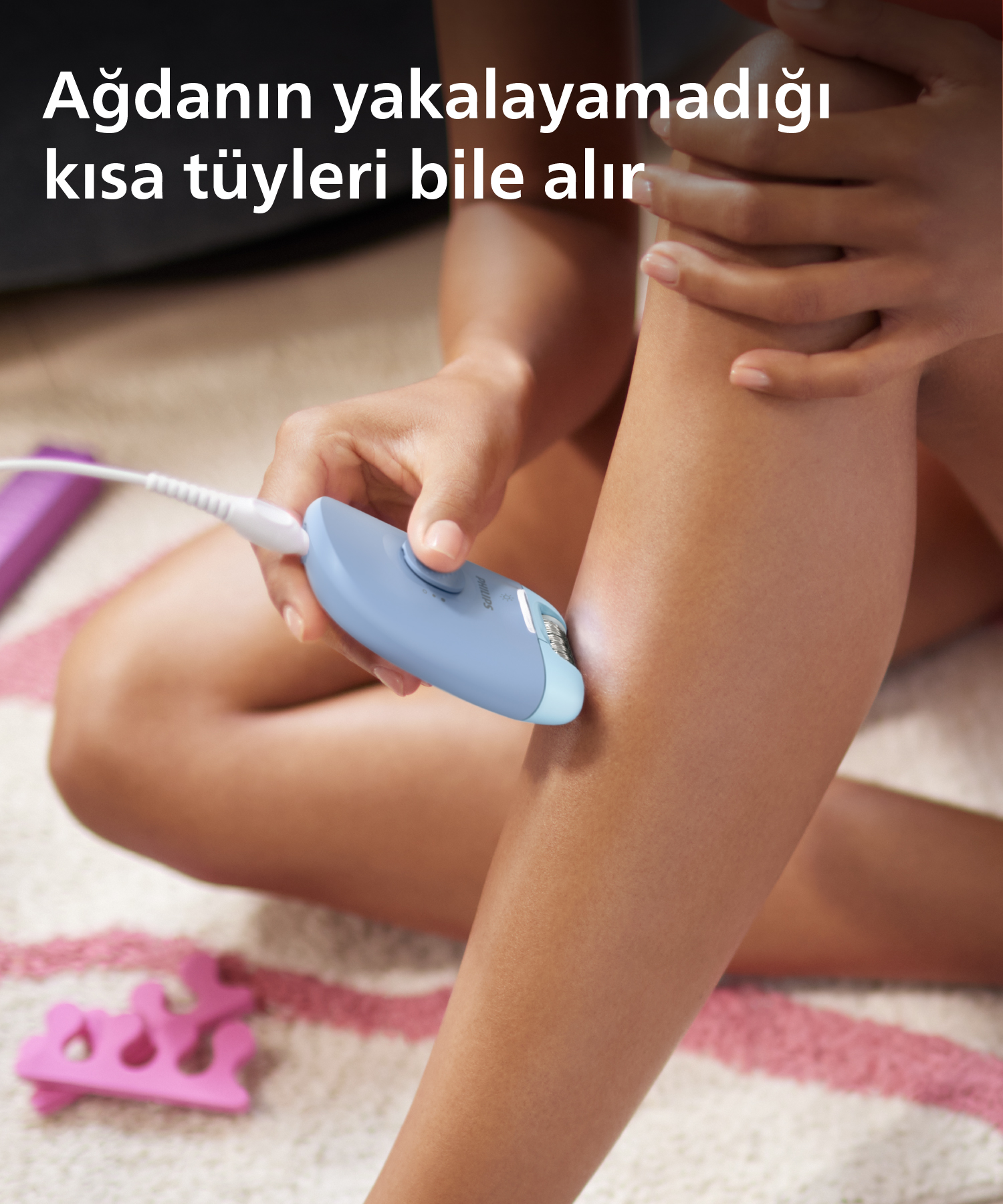 Kadın bacağını mavi bir cihazla depilasyon yapıyor, metin: Ağıdanın yakalayamadığı kısa tüyleri bile alır.