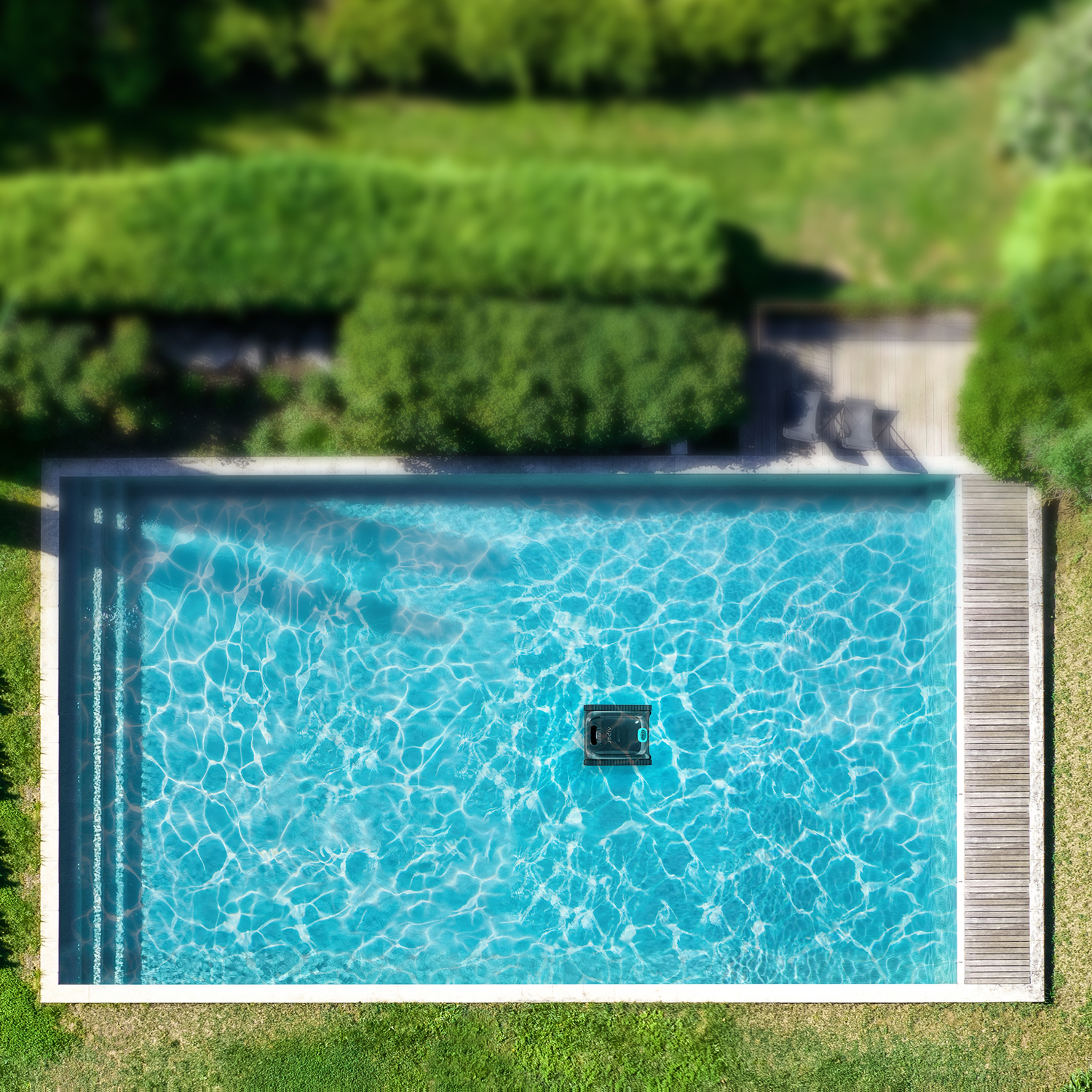 A rectangular pool with clear water, surrounded by grass, wooden deck, and green bushes.