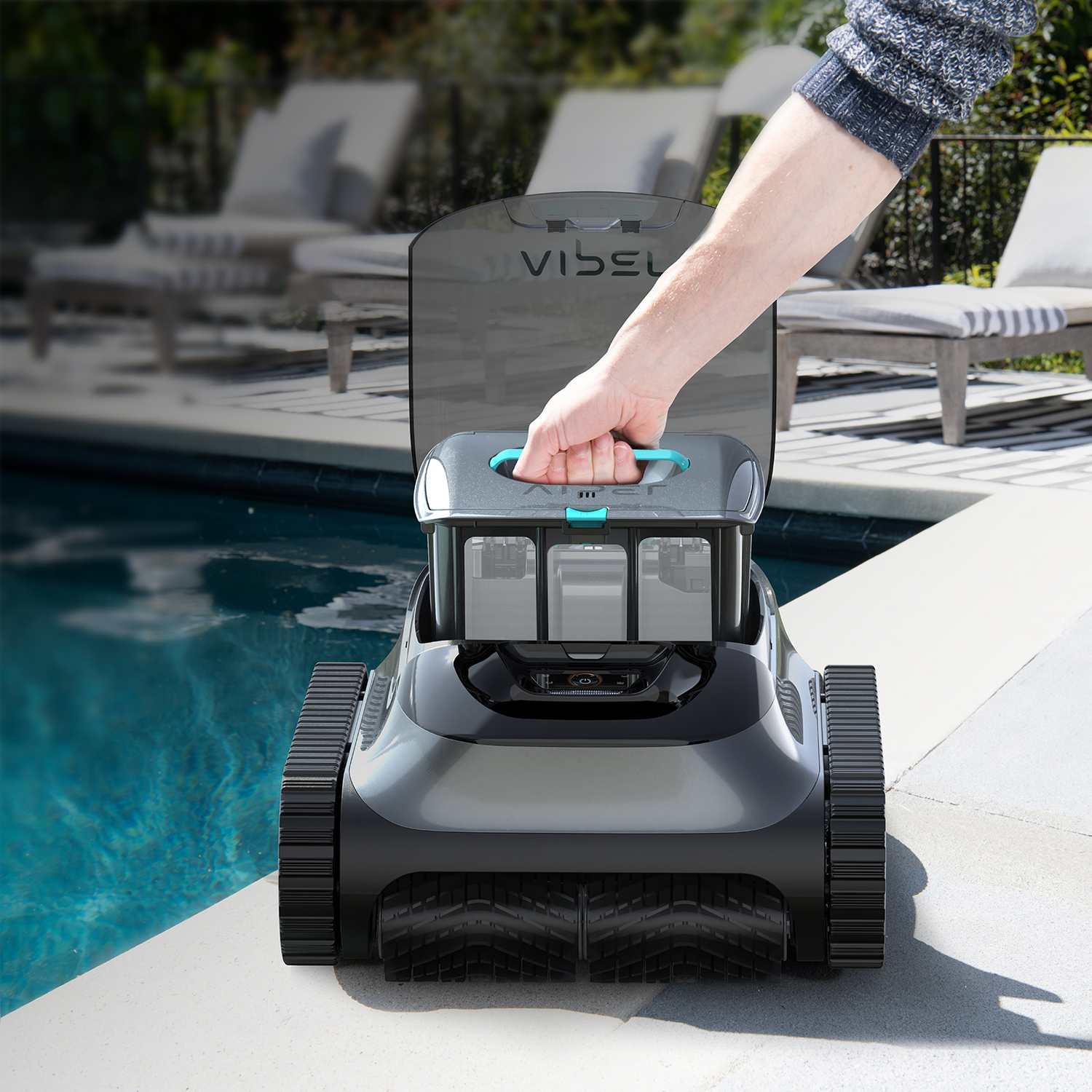 Person holding a pool cleaner robot. The robot is on the pool edge, ready to be used.