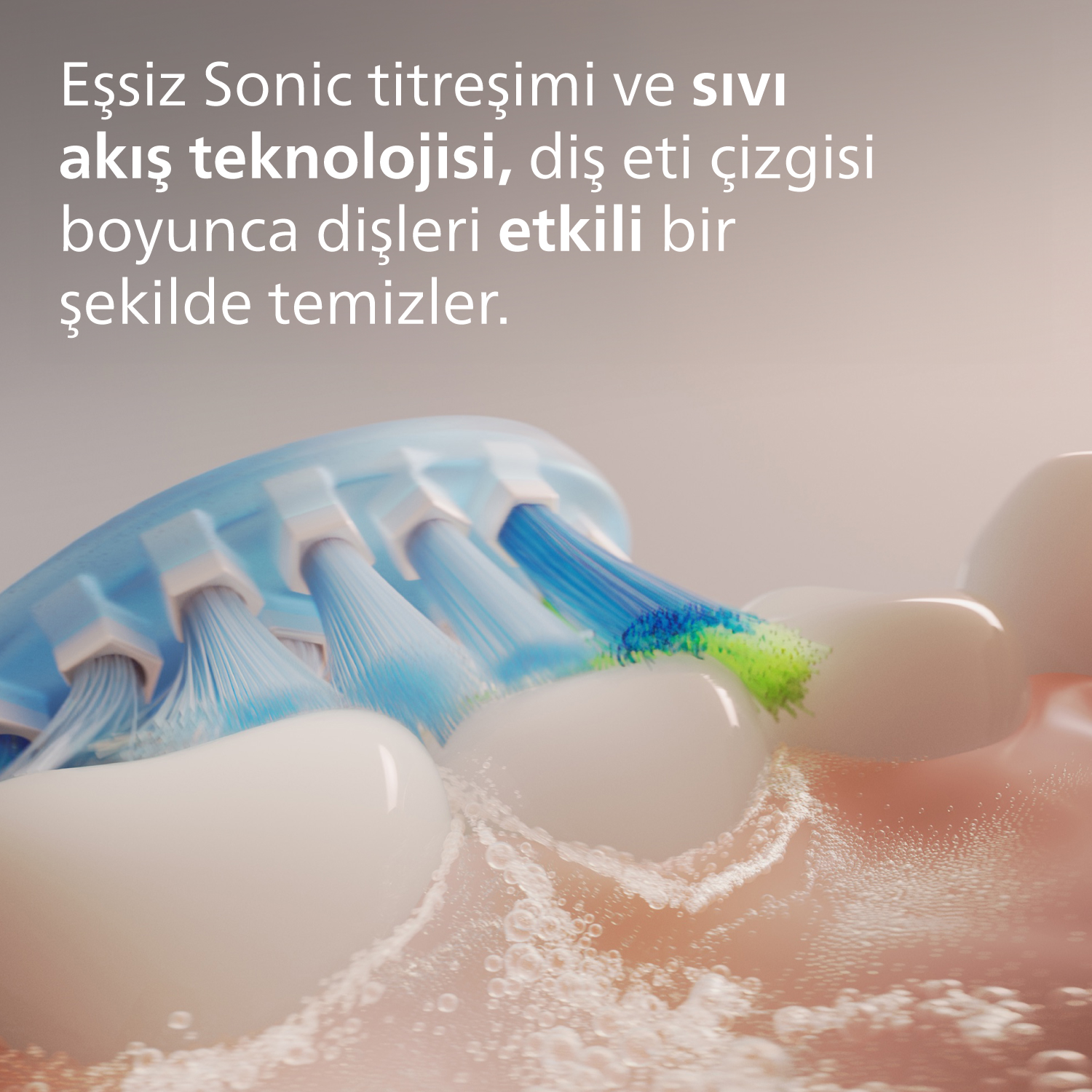 Dişleri temizleyen bir diş fırçası başlığının yakın çekimi. Yeşil uçlu mavi kıllar görünür.