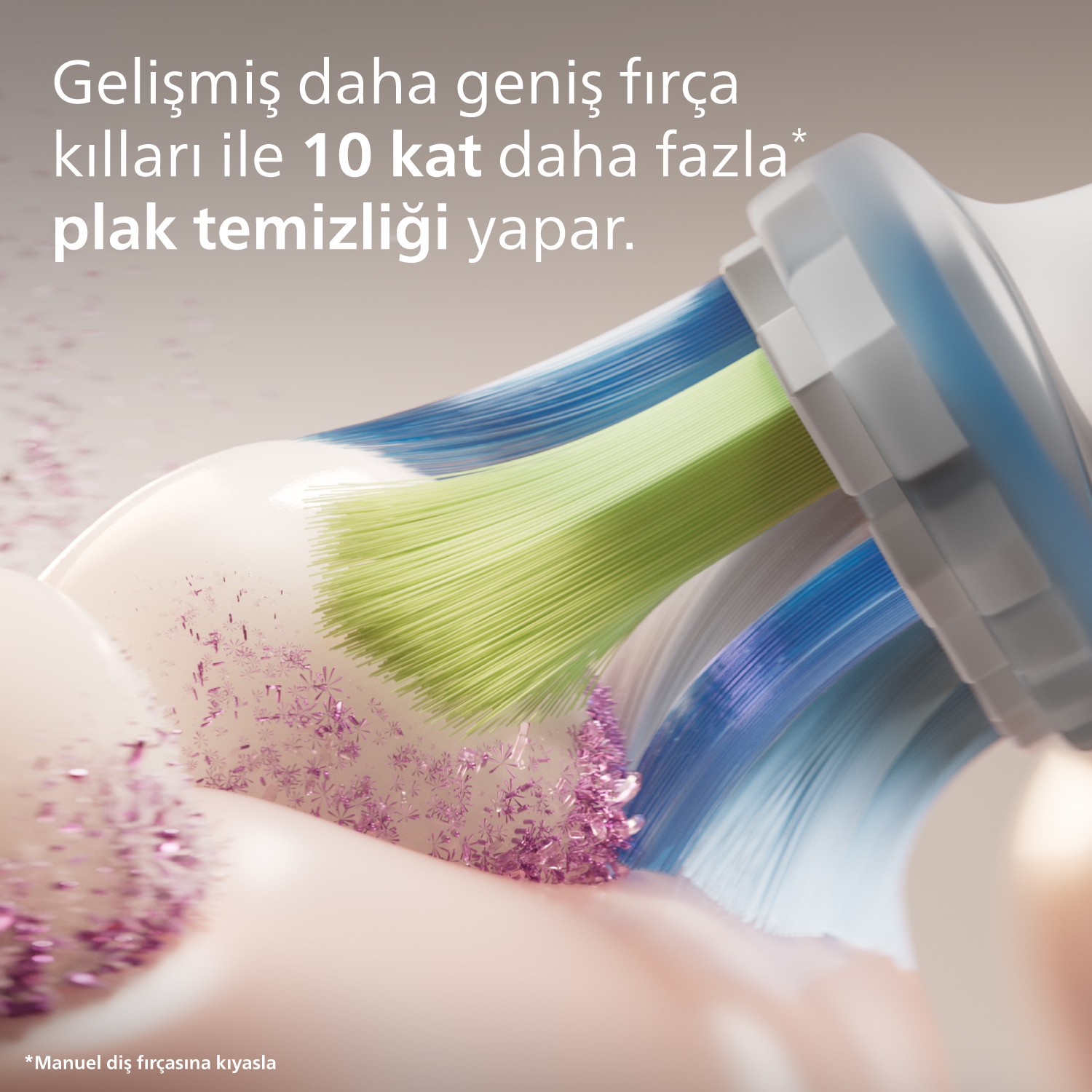 Yeşil ve mavi kıllara sahip bir diş fırçası başlığı, etrafında mor parçacıklar var.