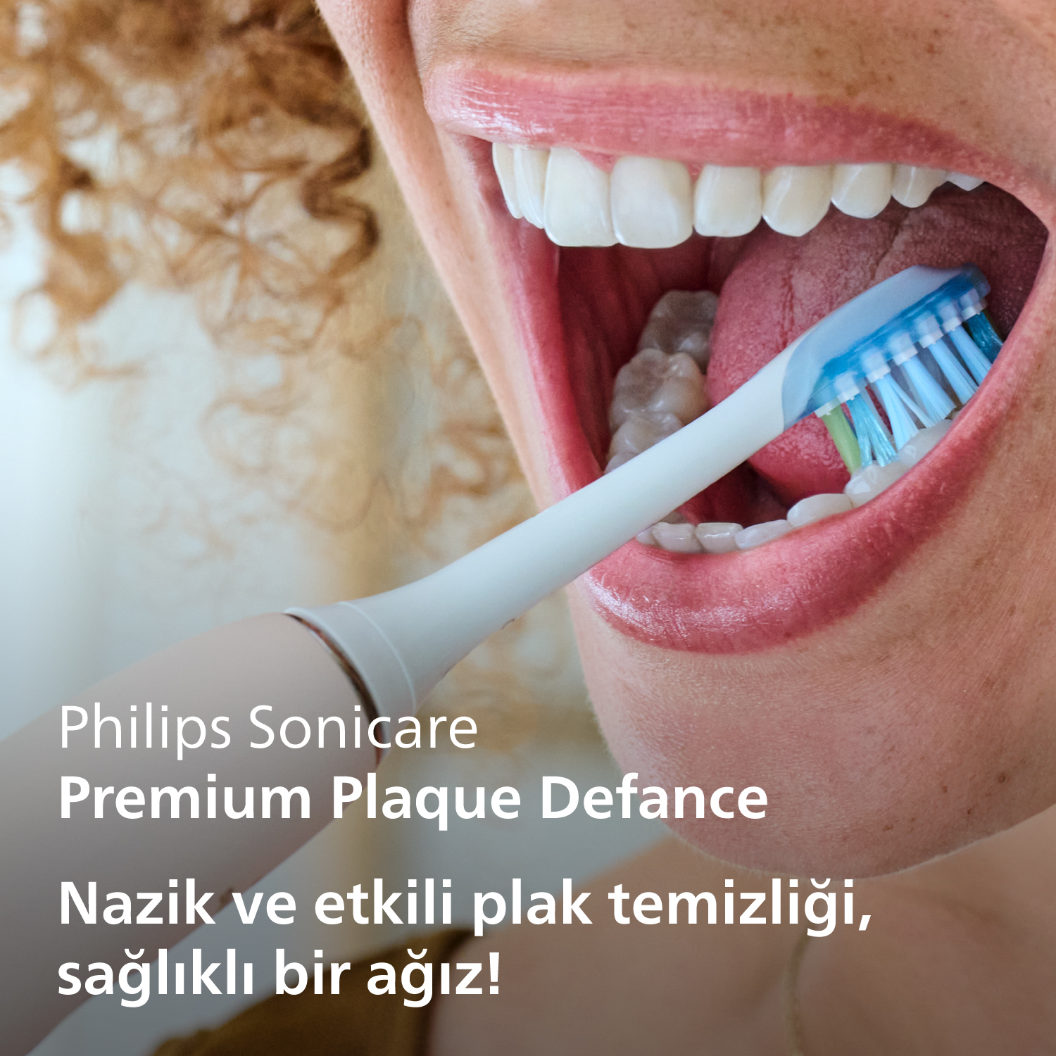 Bir kadının ağzı açık, Philips Sonicare diş fırçasıyla dişlerini fırçalıyor, yakın çekim.
