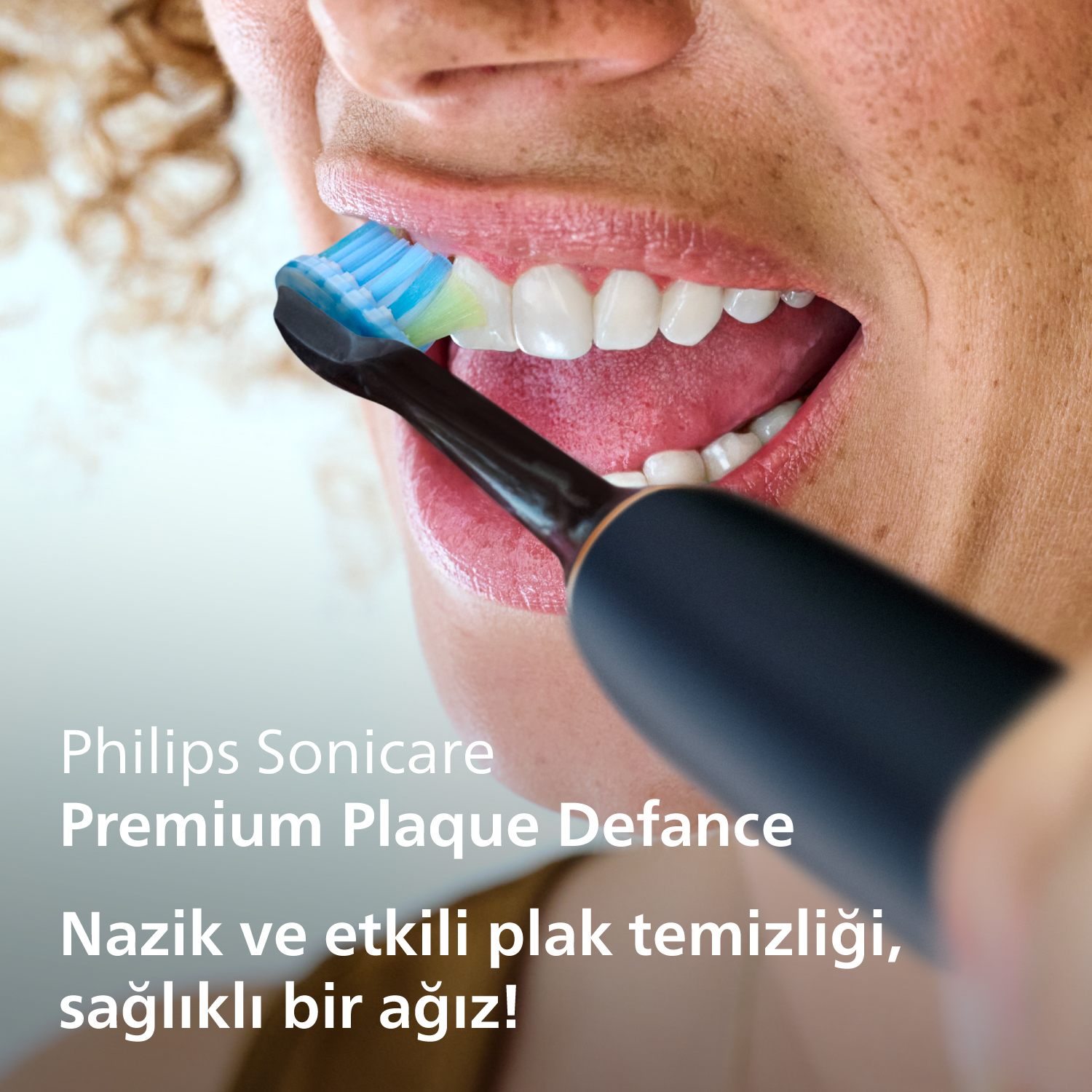 Bir kişi Philips Sonicare elektrikli diş fırçasıyla dişlerini fırçalıyor. Yakın çekim.