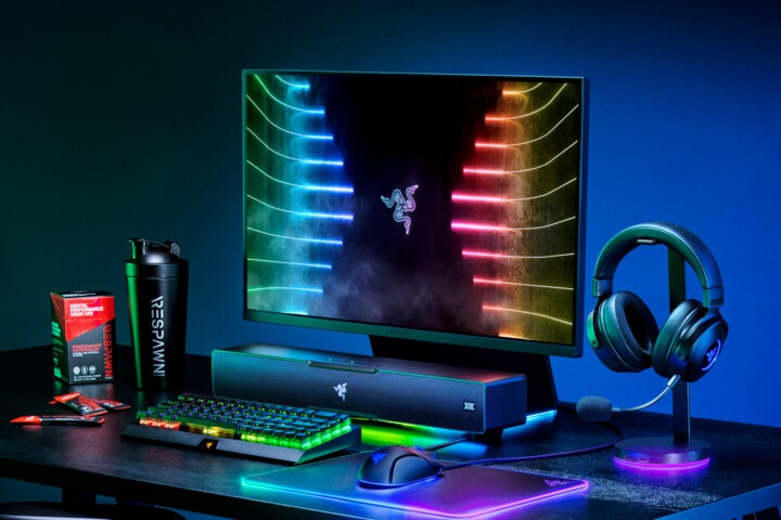 Ustawienia do gier: monitor, klawiatura, mysz, słuchawki, głośnik, butelka wody i napój energetyczny.