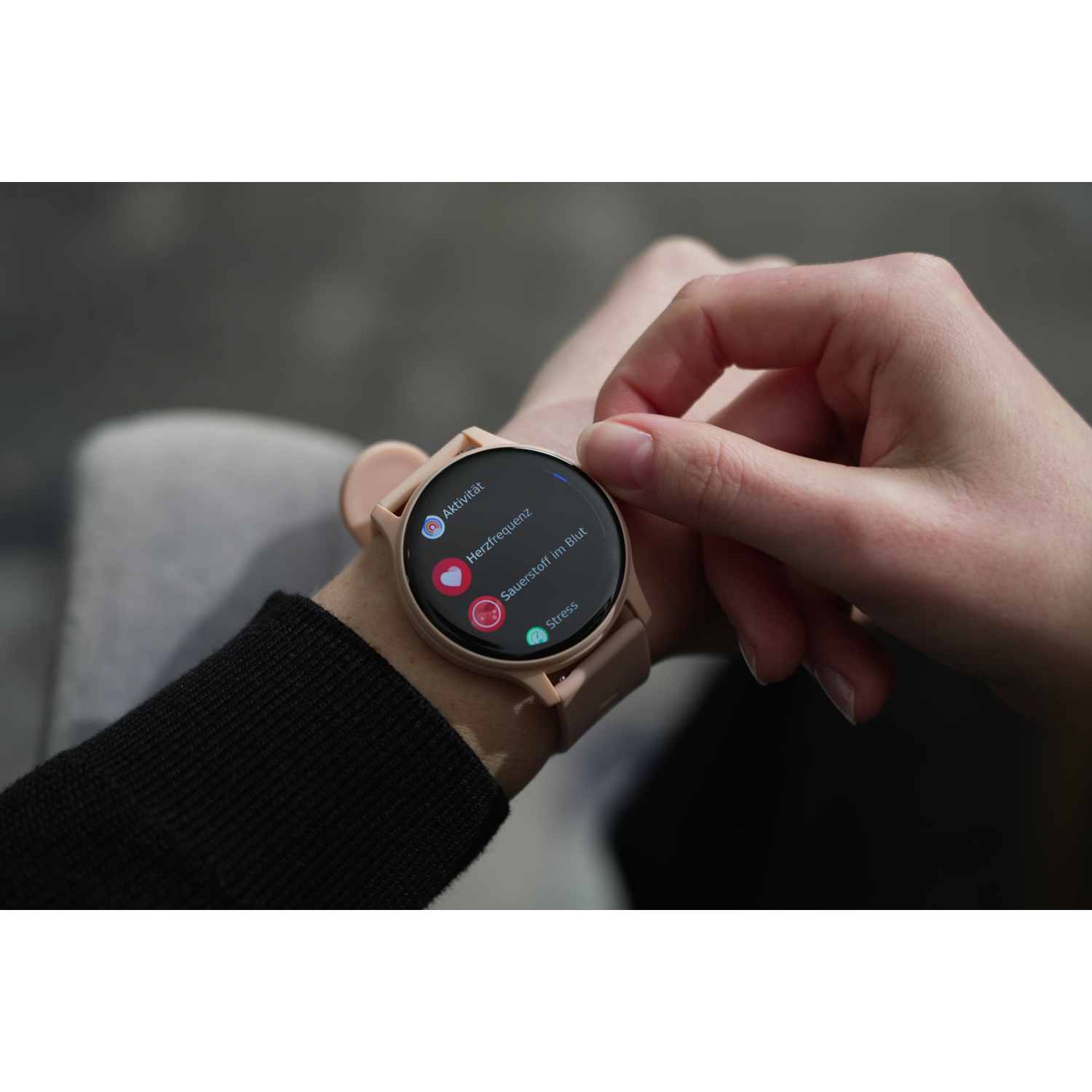 A person's hand wearing a pink smartwatch showing activity, heart rate, and stress.