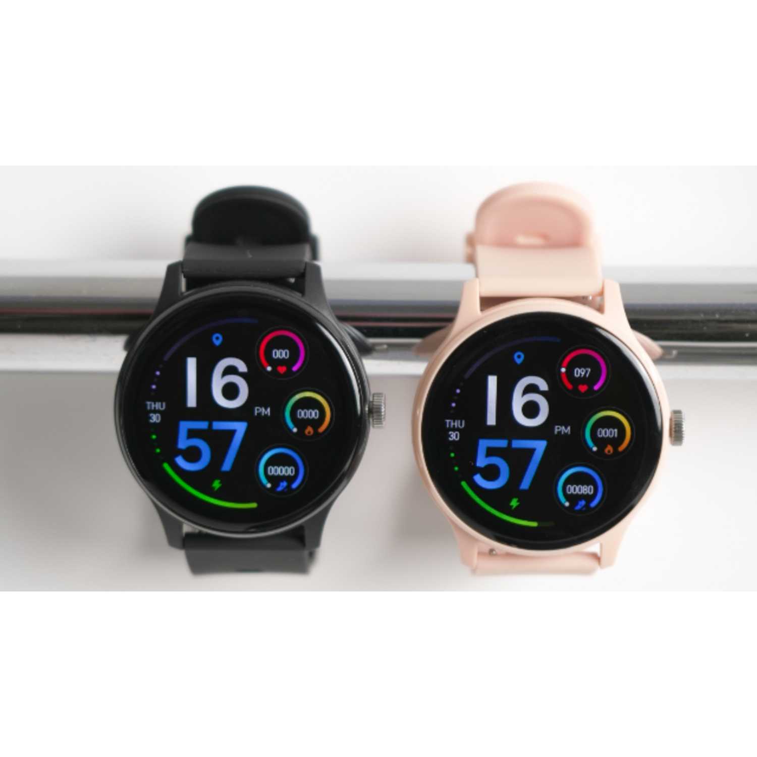 Two smartwatches, one black and one pink, displaying time and health data. Set against a white backdrop.