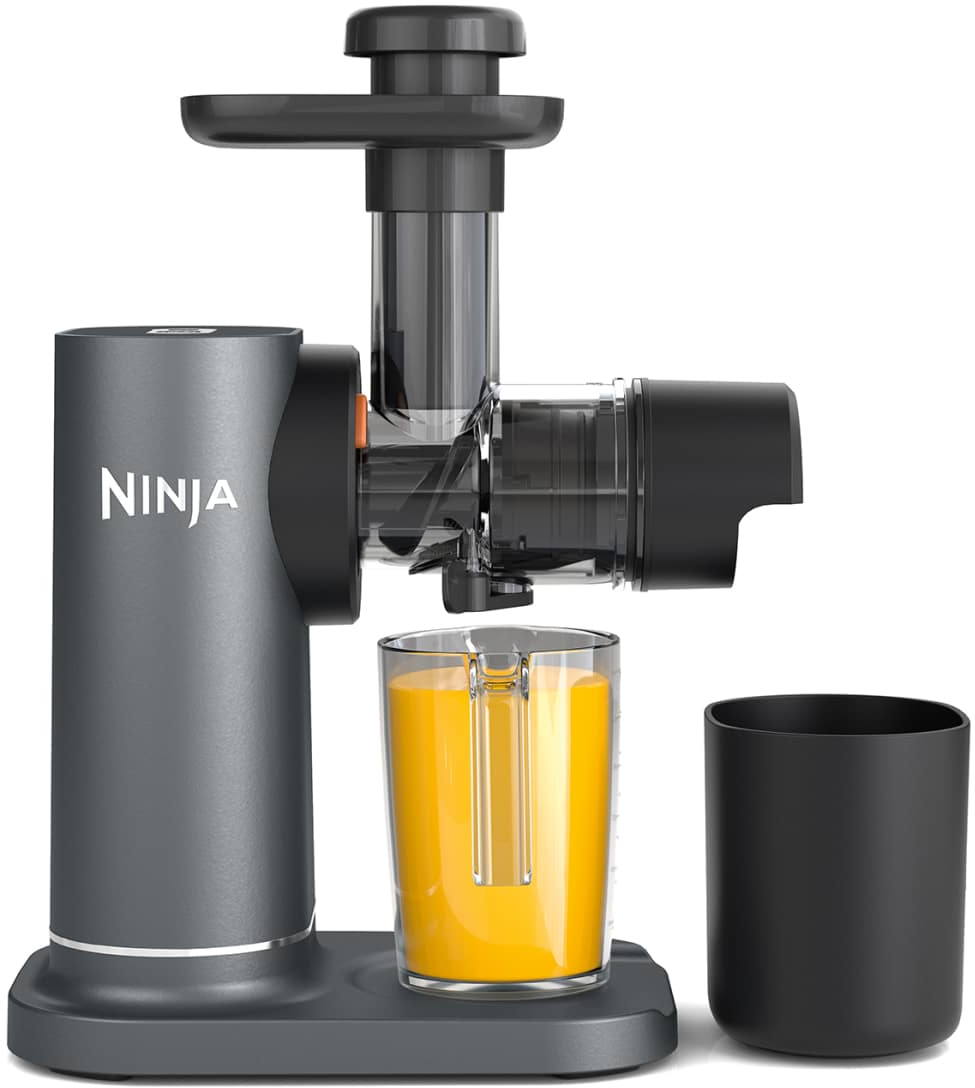 Un estrattore di succo nero e grigio con una tazza di succo giallo e un contenitore nero di fronte.