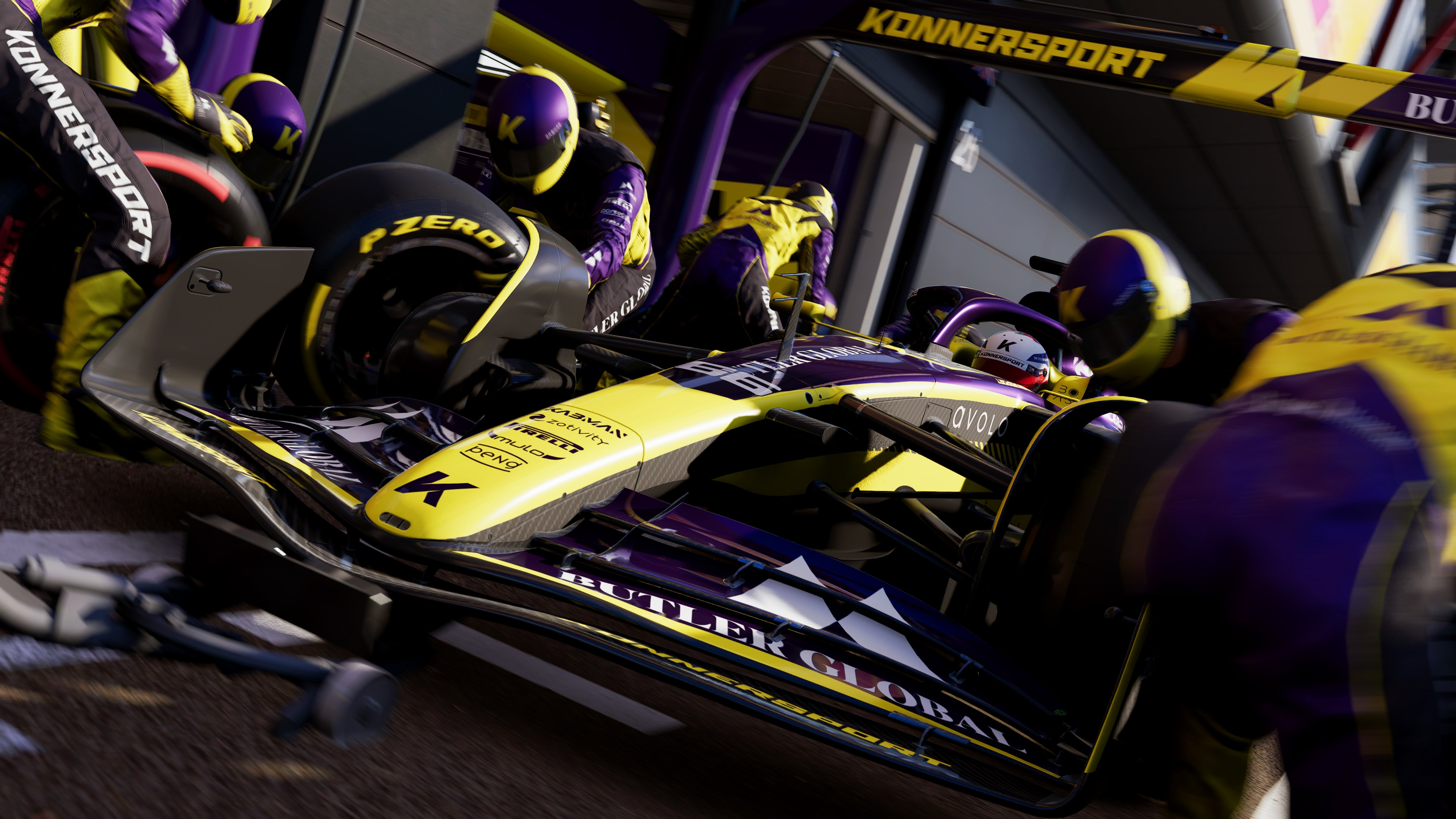 Ein Formel-1-Auto beim Boxenstopp, mit Teammitgliedern und Logos, Actionaufnahme.