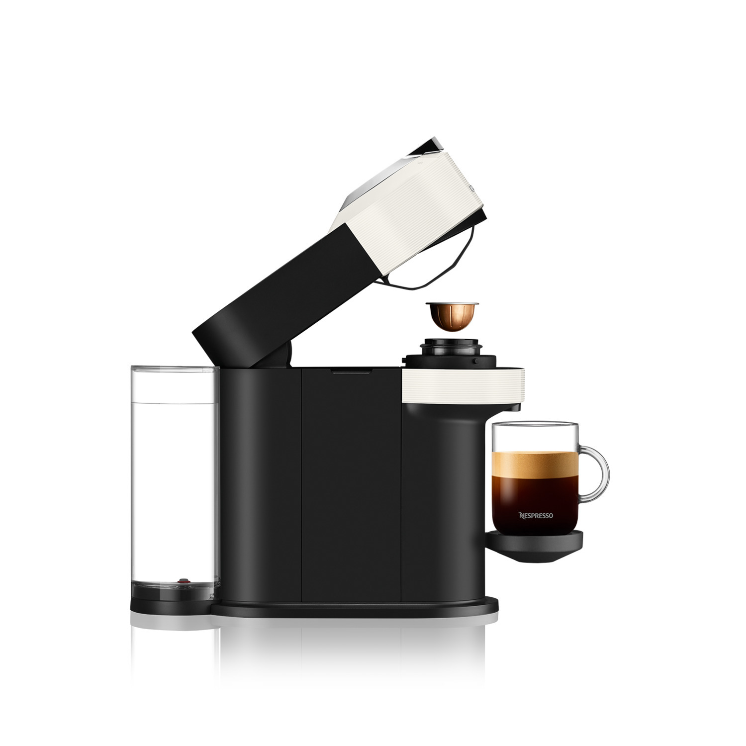 Black and white Nespresso coffee machine with a cup of coffee. A capsule is ready to be brewed.