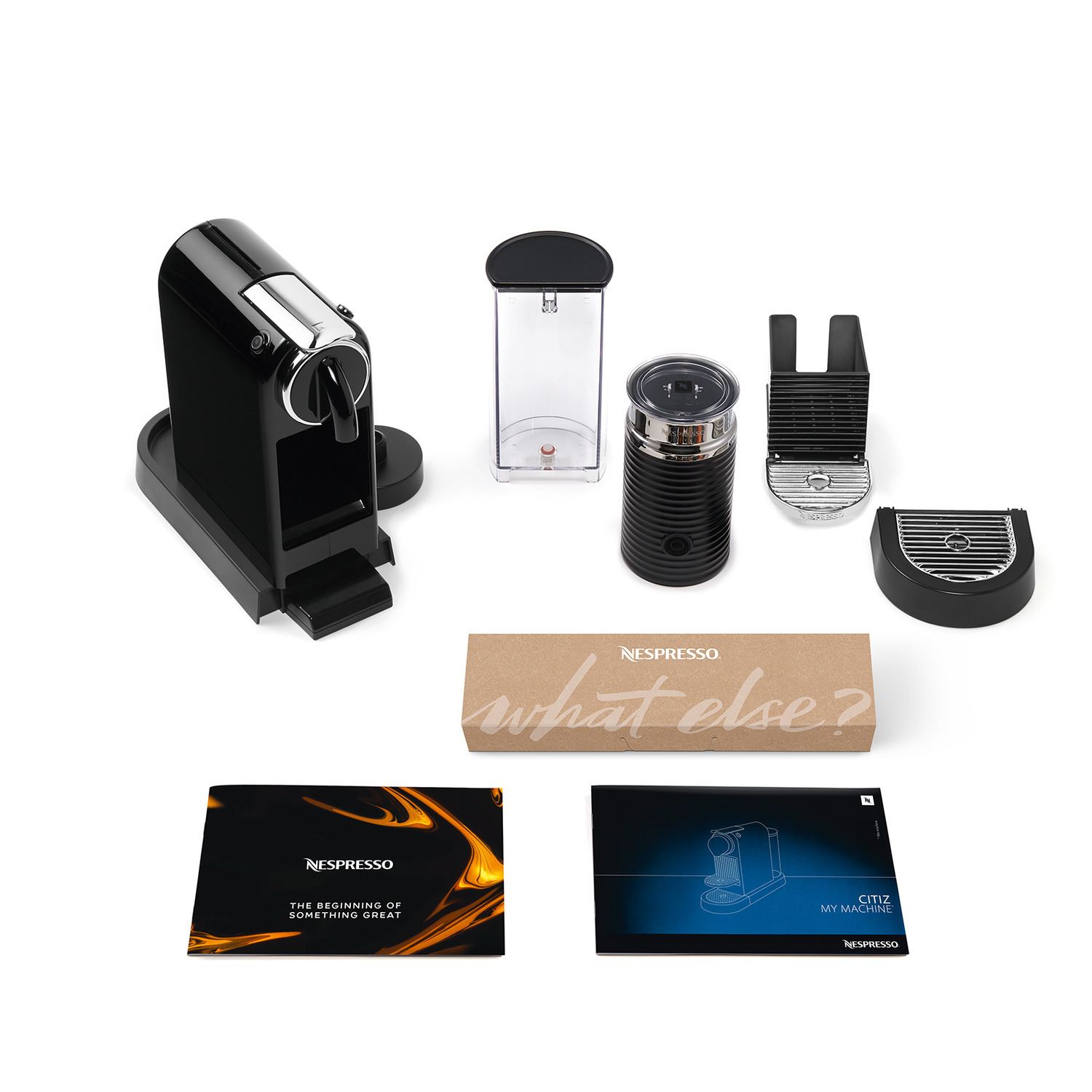 A black Nespresso machine and accessories, including a milk frother and coffee pods.