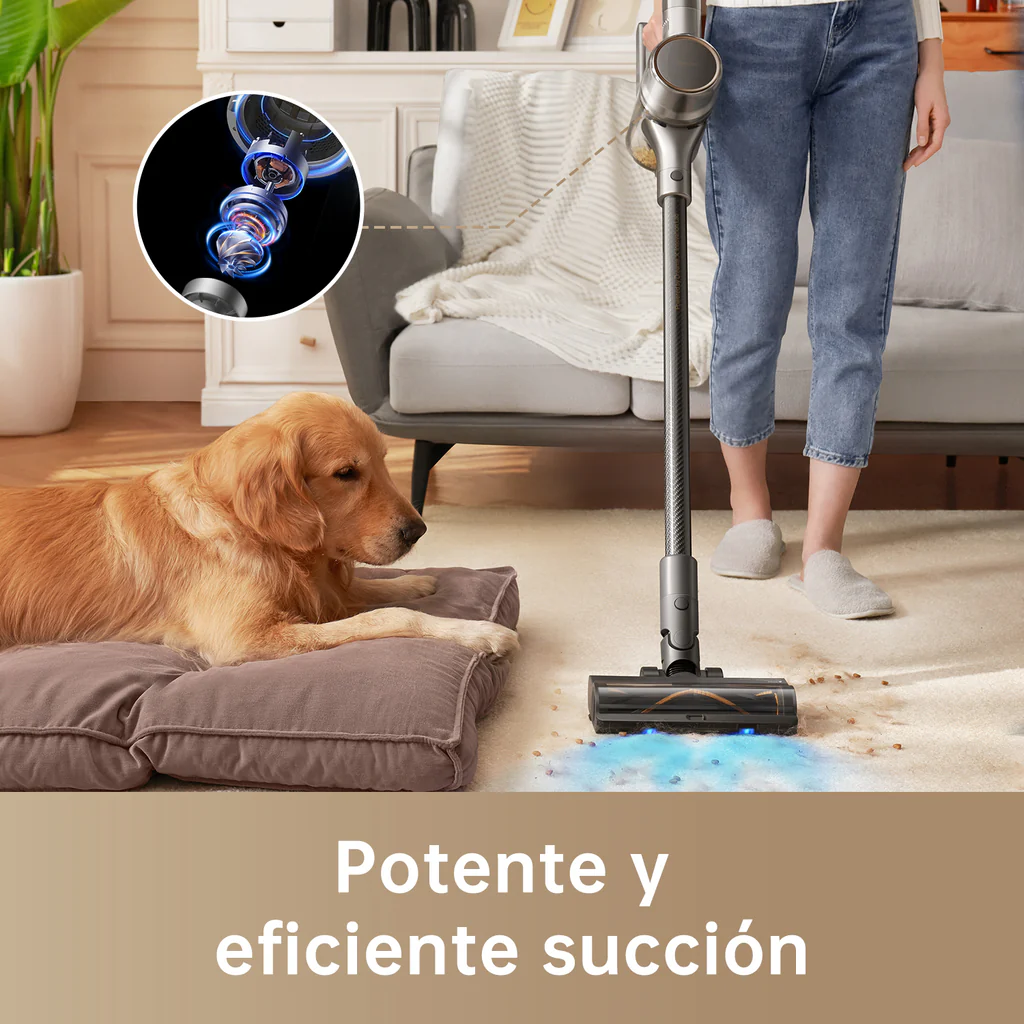 Una persona aspira una alfombra. Un golden retriever yace en una almohada. La aspiradora es de diseño moderno.