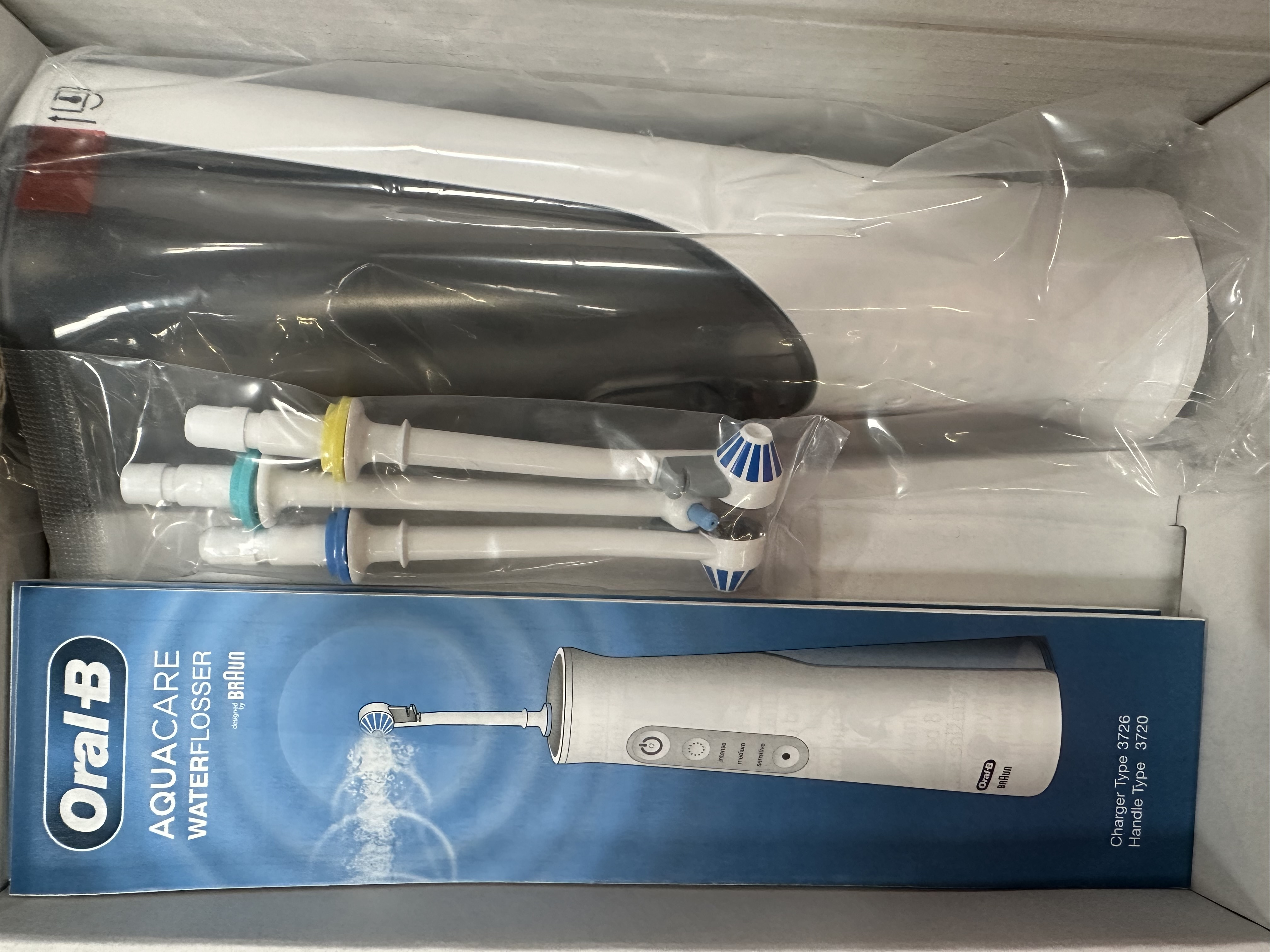 Irygator Oral-B Aquacare w pudełku, z widocznymi częściami.