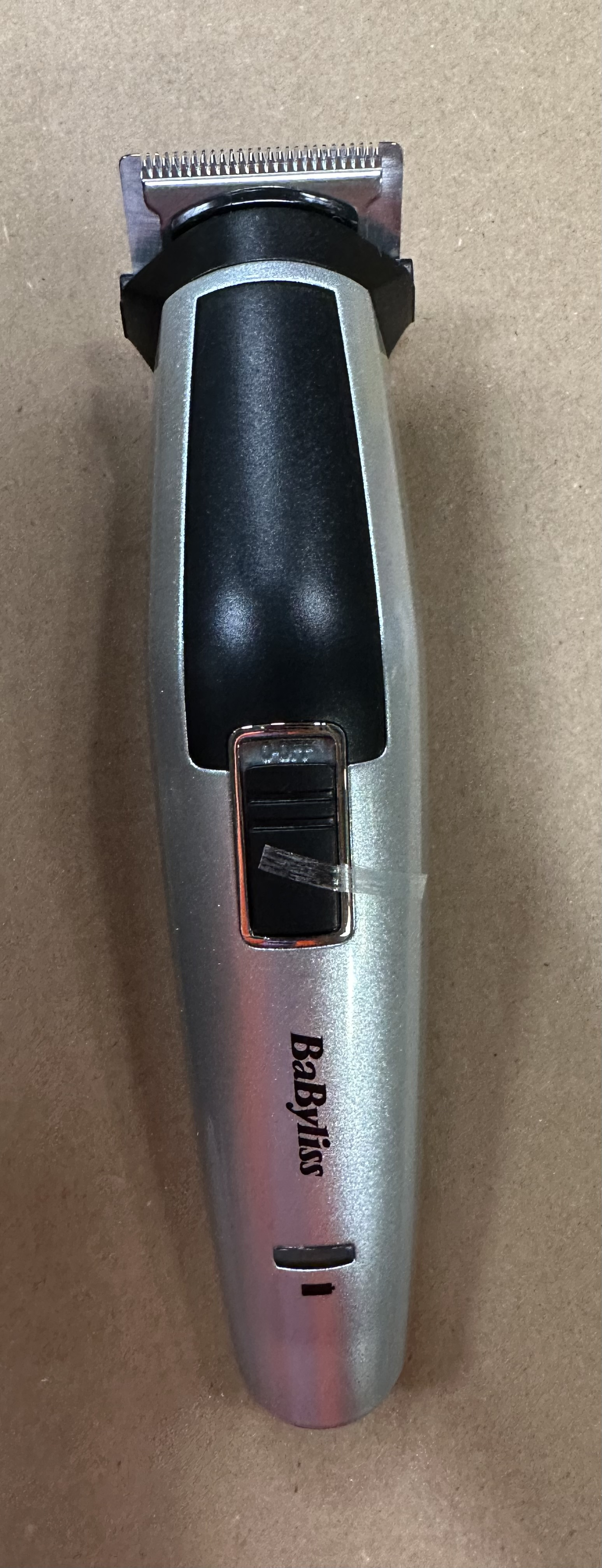 Srebrno-czarna maszynka do strzyżenia brody Babyliss, z widoczną nazwą marki.