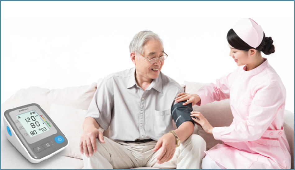 Starszy mężczyzna, któremu pielęgniarka mierzy ciśnienie krwi. Monitor jest po lewej stronie.