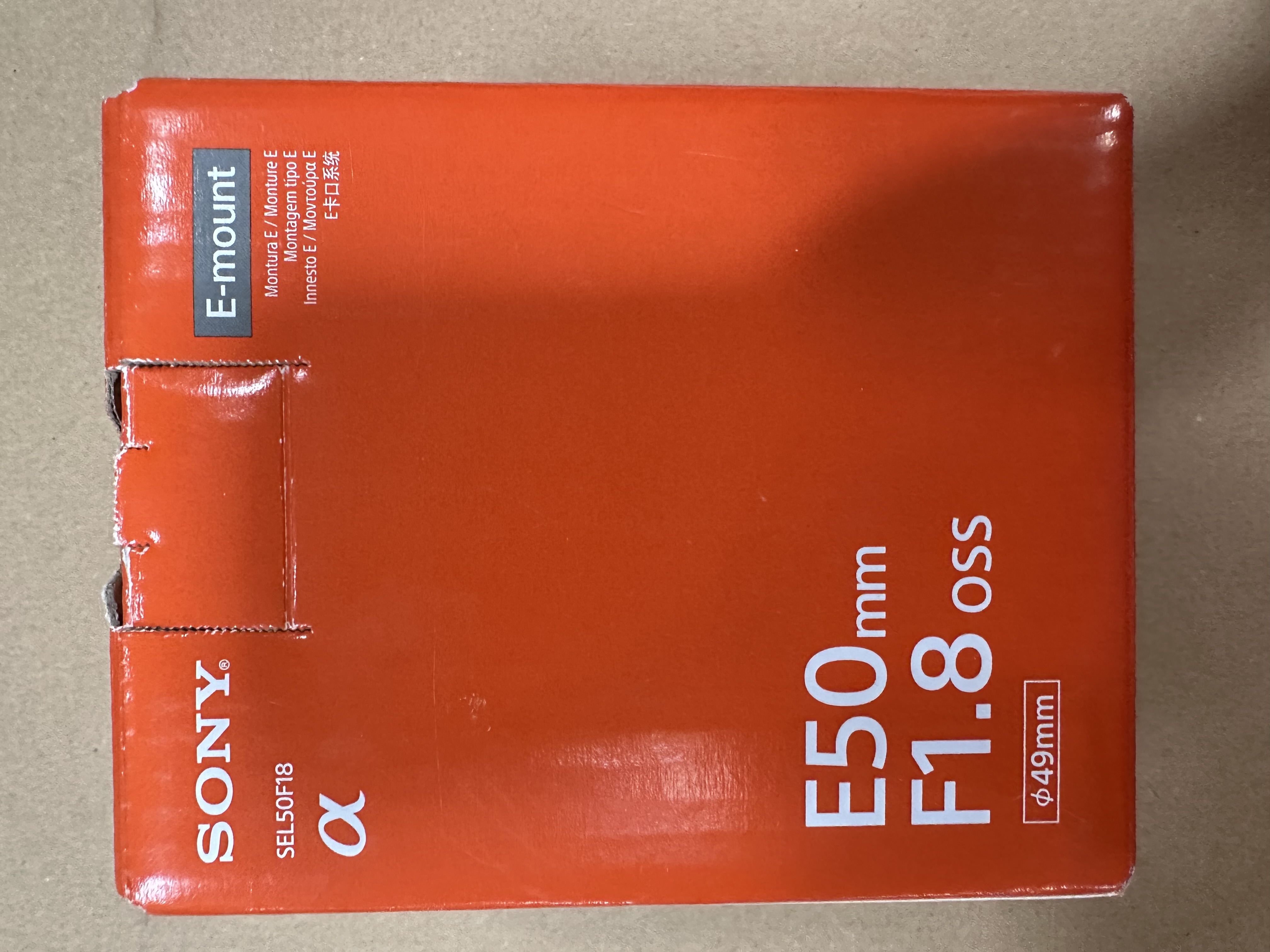 Brązowe pudełko z logo Sony i napisem 'E50mm F1.8 OSS'.