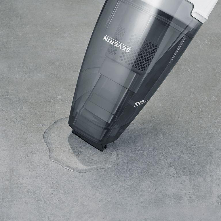 Handstaubsauger auf grauer Oberfläche. Auf der Oberfläche befindet sich eine Wasserpfütze.