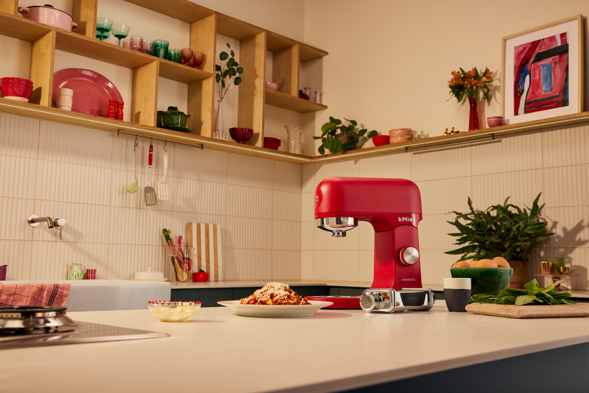 Scena kuchenna z czerwonym mikserem Kenwood kMix. Makaron, przybory i składniki na blacie.