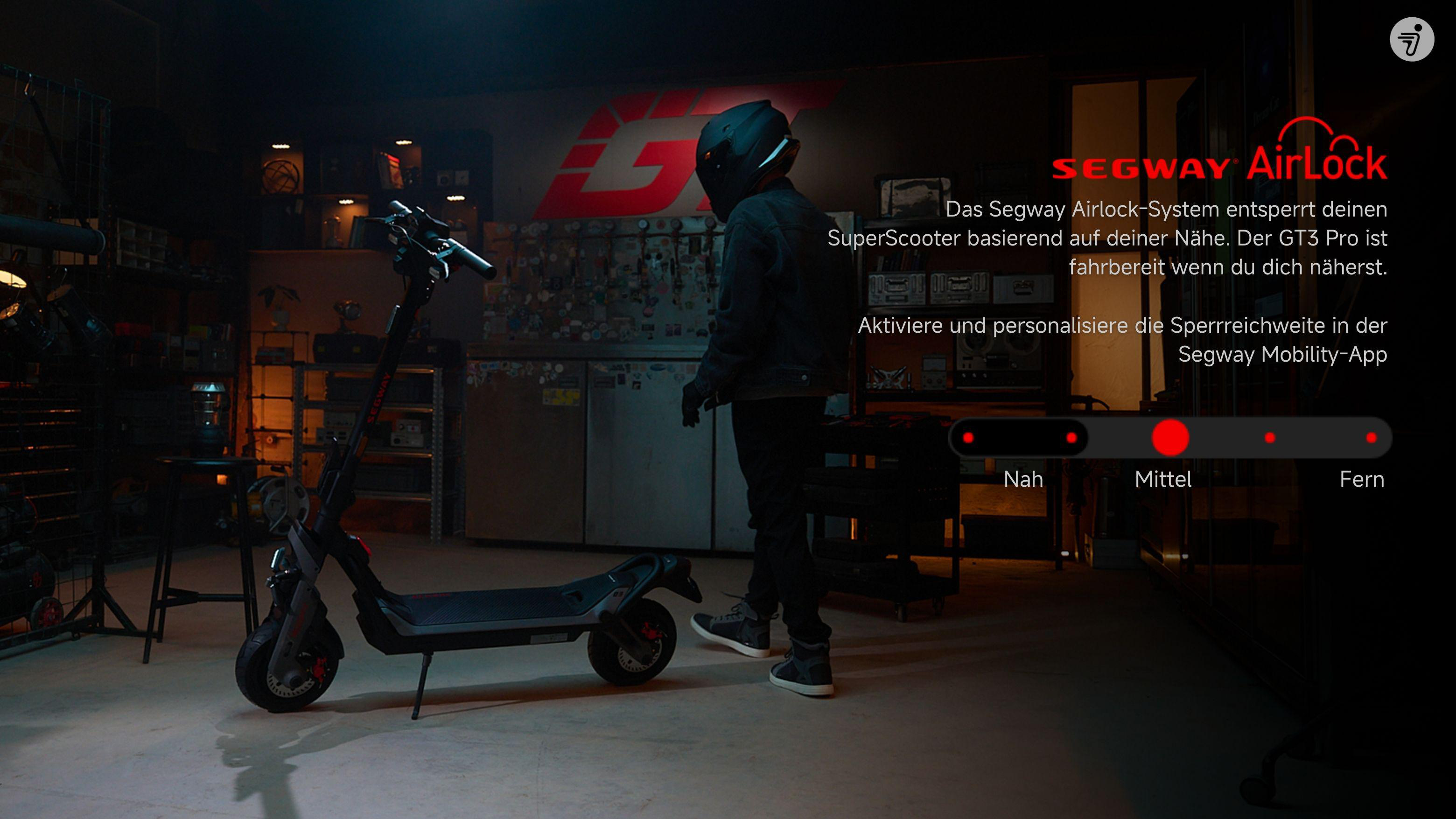Eine Person steht neben einem Segway-Roller in einer Garage mit einem Werbebildschirm.