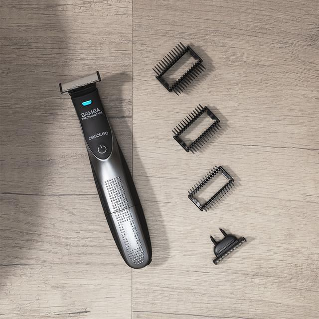 Golarka elektryczna z trzema głowicami tnącymi i przyciskiem zasilania na drewnianej powierzchni.