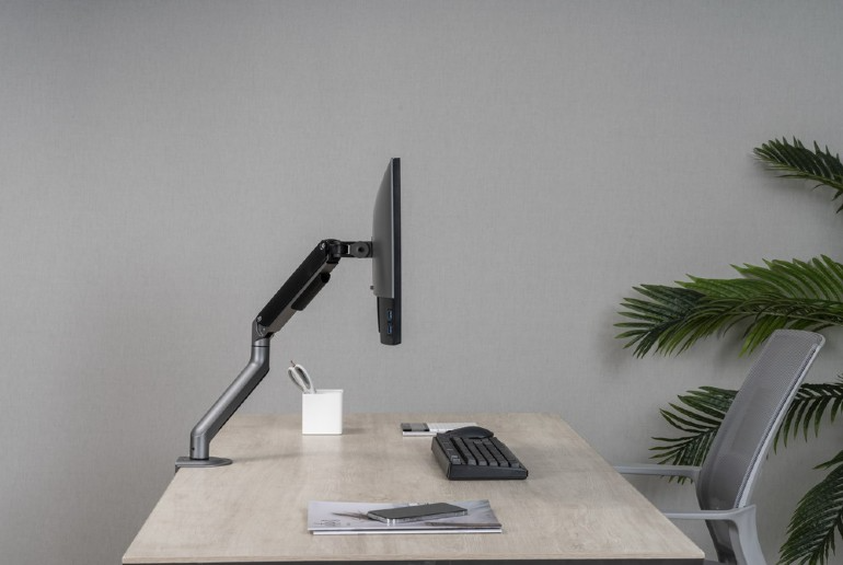 Egy fehér eszköz állvánnyal és USB-C porttal az oldalán, fehér felületen.