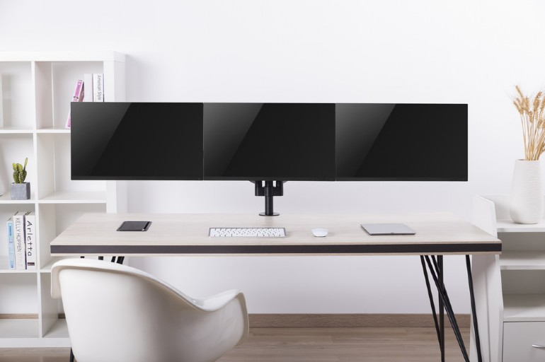 Három monitor egy asztalon. Billentyűzet, egér és tablet látható.
