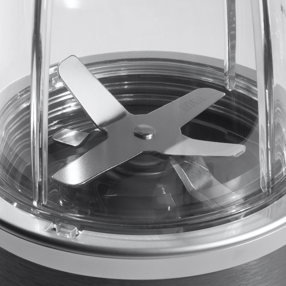 Zbliżenie na ostrze blendera w przezroczystym pojemniku.