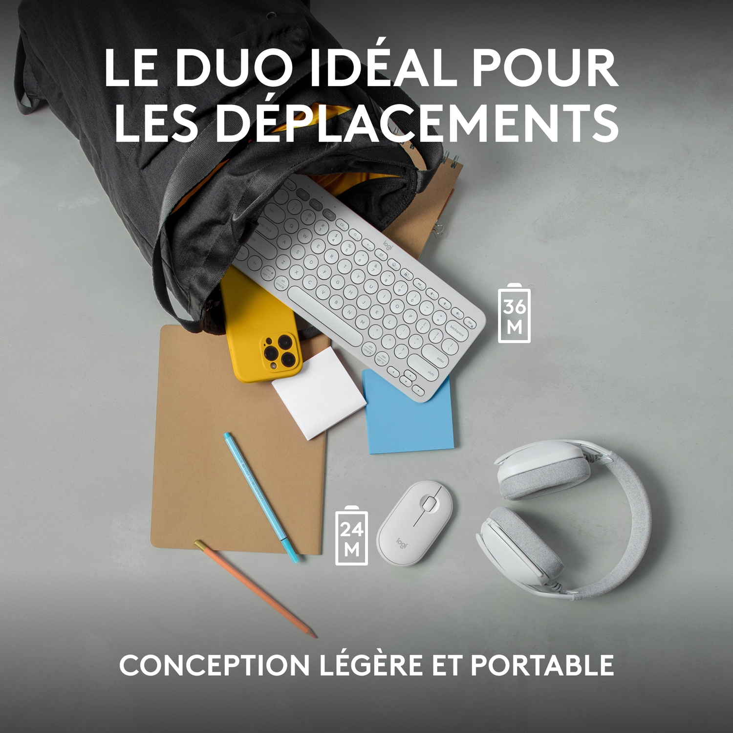 Un sac à dos noir, clavier, téléphone, bloc-notes, souris et casque sur une surface.