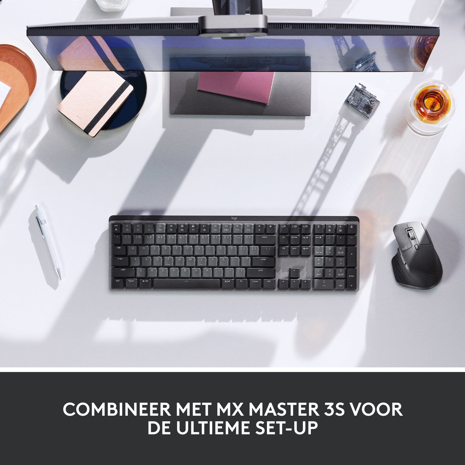 A top-down shot of a desk with a keyboard, mouse, monitor, and accessories.