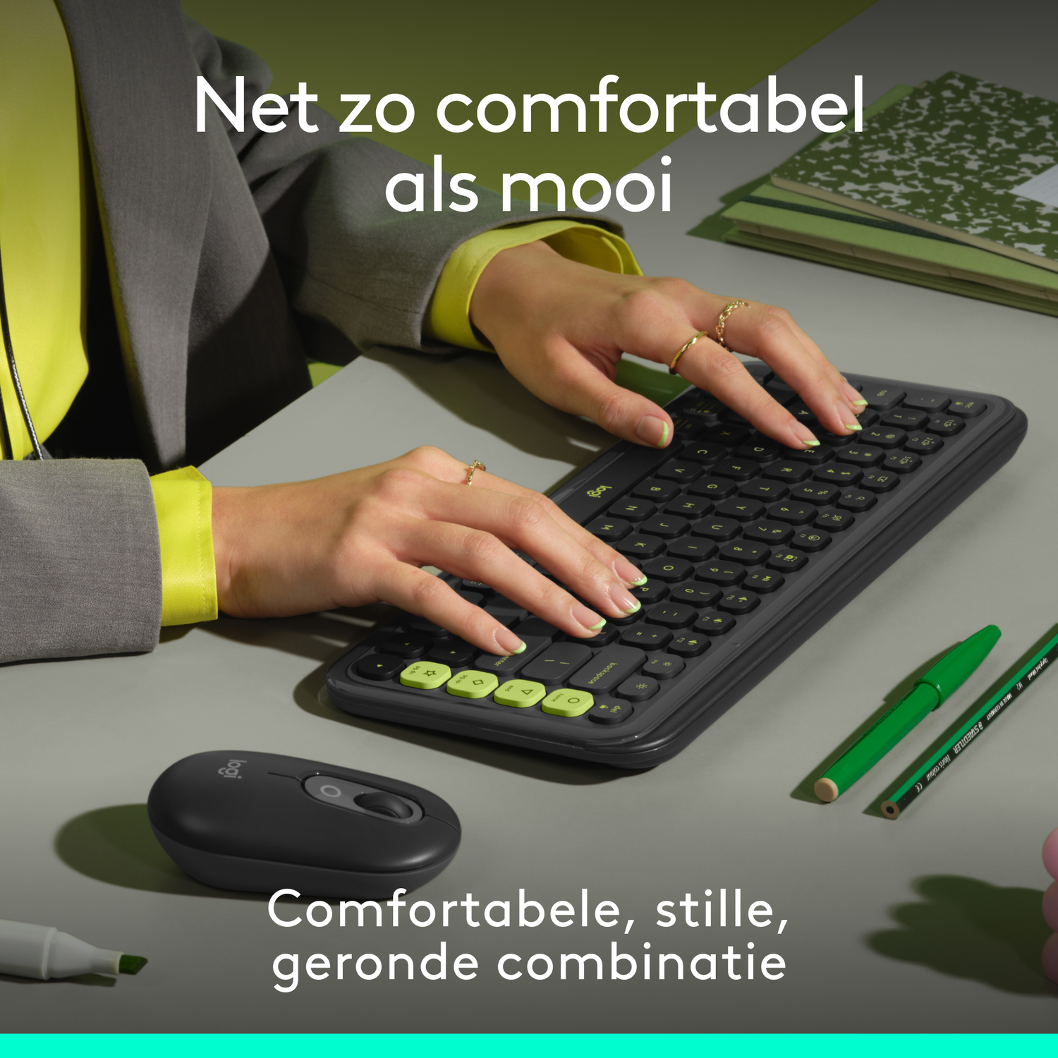 Een persoon die een toetsenbord en muis gebruikt, naast een notitieboek en pen.