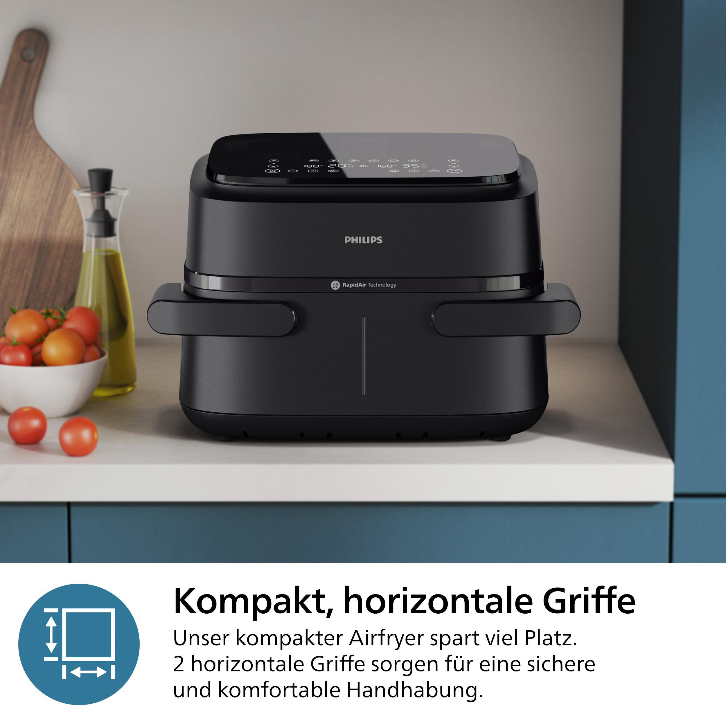 Schwarze Philips Heißluftfritteuse auf weißer Oberfläche, Cherrytomaten daneben.